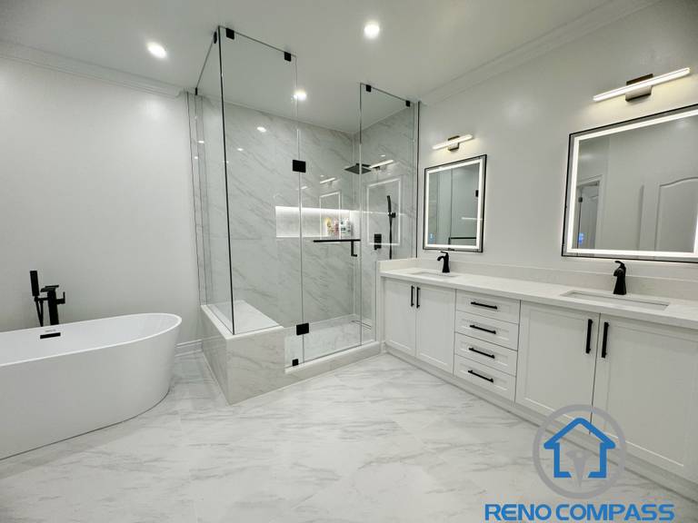 This modern Vaughan bathroom renovation features a clean and elegant layout with a double vanity, quartz countertop, and sleek black fixtures. A frameless glass shower with large-format marble-look tiles creates a spacious and luxurious feel, while the freestanding bathtub adds a spa-like touch. Completed by a professional Toronto Renovation Company, this bathroom design focuses on functionality, durability, and timeless modern aesthetics.