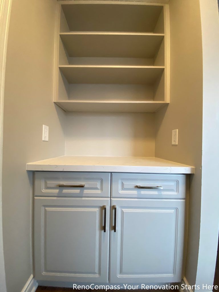 This Mississauga interior renovation features a custom-built storage cabinet with open shelving, designed to improve organization and everyday functionality. The soft gray cabinetry is paired with a durable countertop and integrated drawers, offering practical storage for household items. Open shelves above provide easy access and visual balance, making this built-in storage solution both functional and aesthetically clean for modern interior living spaces.