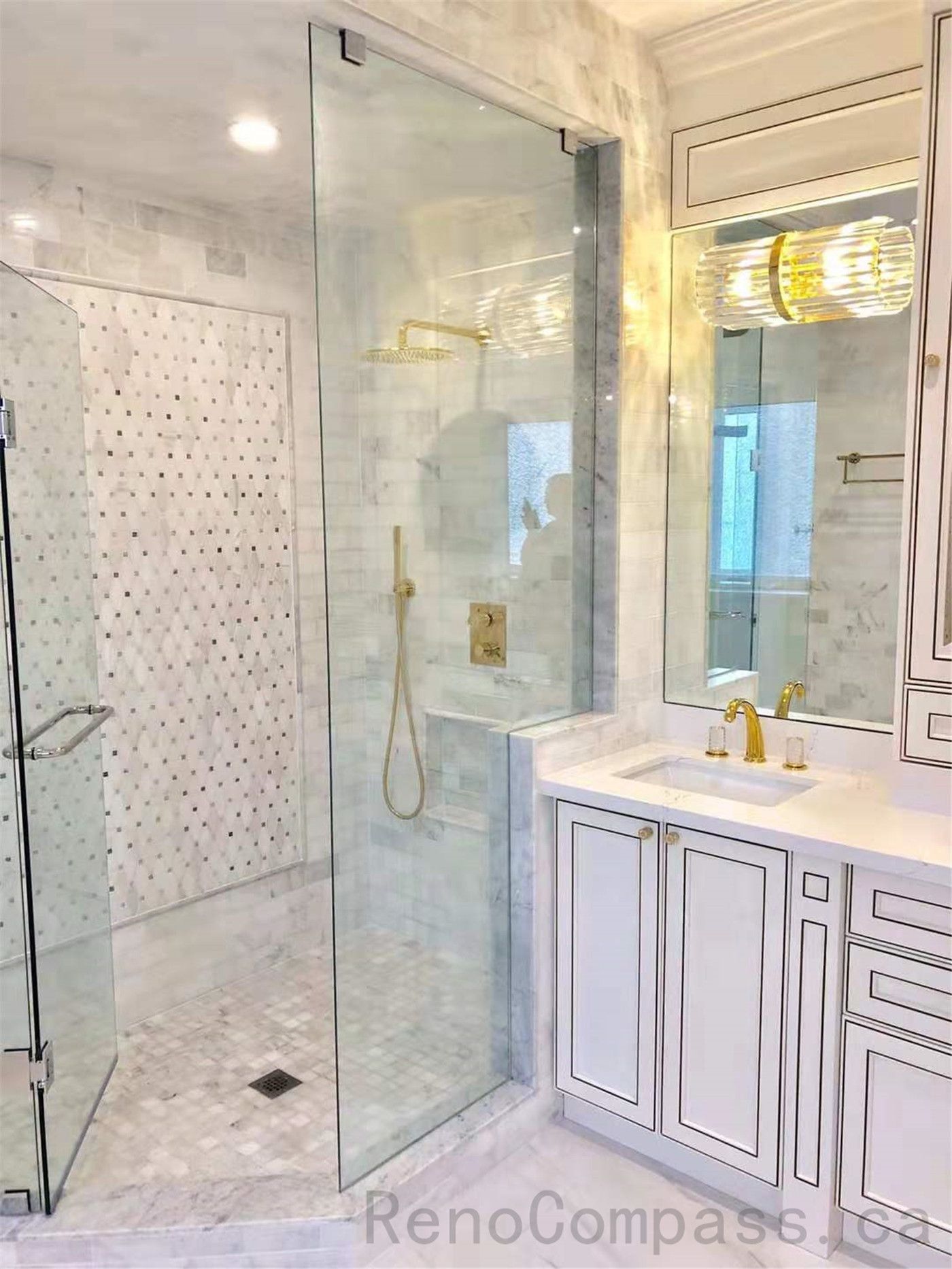 This North York bathroom renovation presents a spacious walk-in shower with frameless glass panels, marble tile finishes, and a custom vanity with integrated storage. Coordinated gold fixtures and layered lighting enhance both functionality and visual balance in this primary bathroom design.