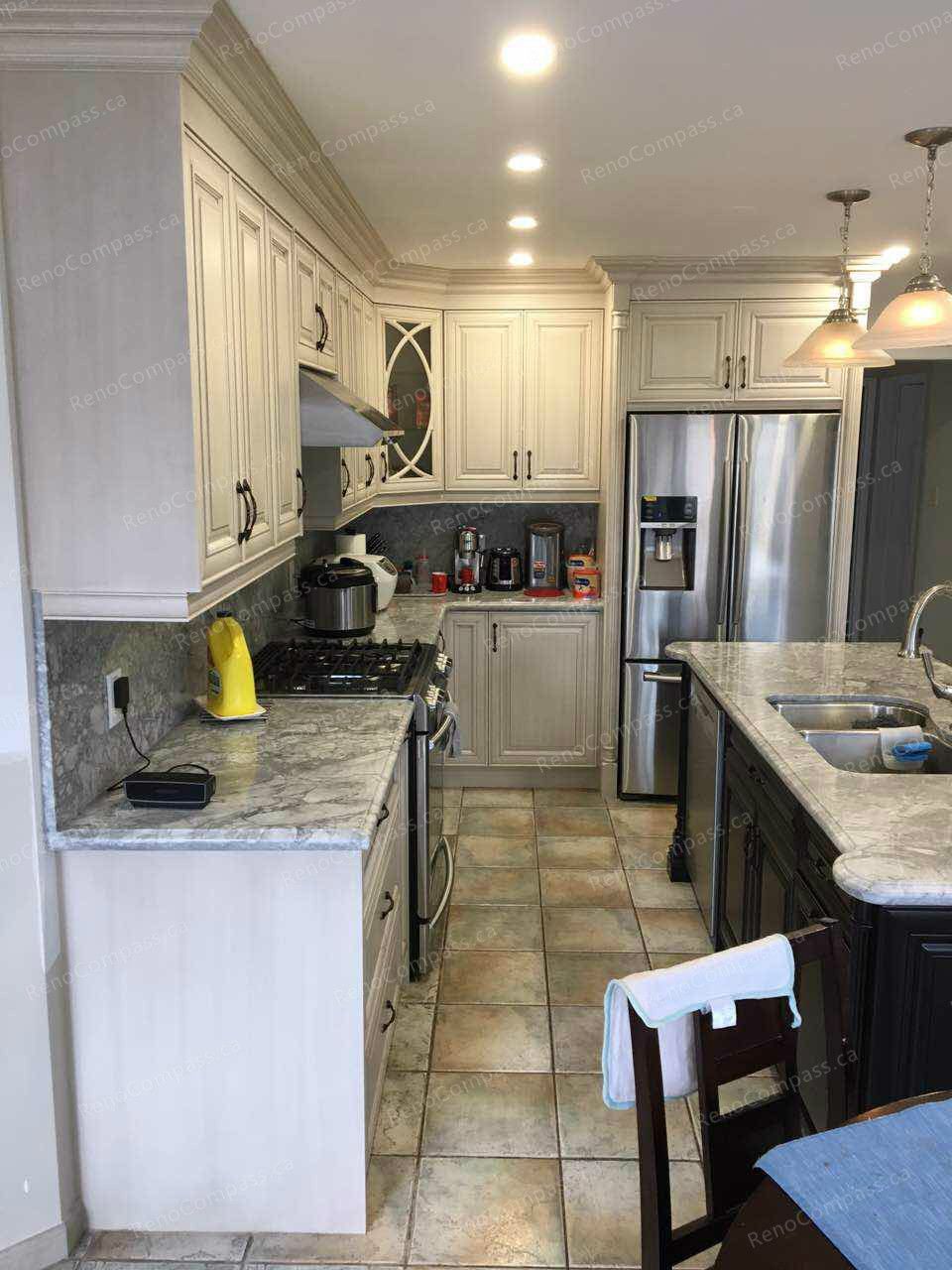This Oakville interior renovation highlights a refined kitchen upgrade featuring custom cream-colored cabinetry, marble-style countertops, and a functional layout designed for modern family living. Stainless steel appliances, under-cabinet lighting, and detailed crown molding enhance both style and efficiency. The spacious design improves workflow while maintaining a warm, elegant atmosphere, showcasing quality craftsmanship and thoughtful interior renovation for Oakville homeowners.