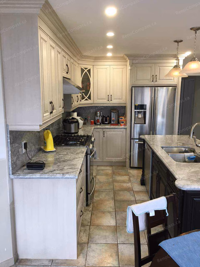 This Oakville interior renovation highlights a refined kitchen upgrade featuring custom cream-colored cabinetry, marble-style countertops, and a functional layout designed for modern family living. Stainless steel appliances, under-cabinet lighting, and detailed crown molding enhance both style and efficiency. The spacious design improves workflow while maintaining a warm, elegant atmosphere, showcasing quality craftsmanship and thoughtful interior renovation for Oakville homeowners.