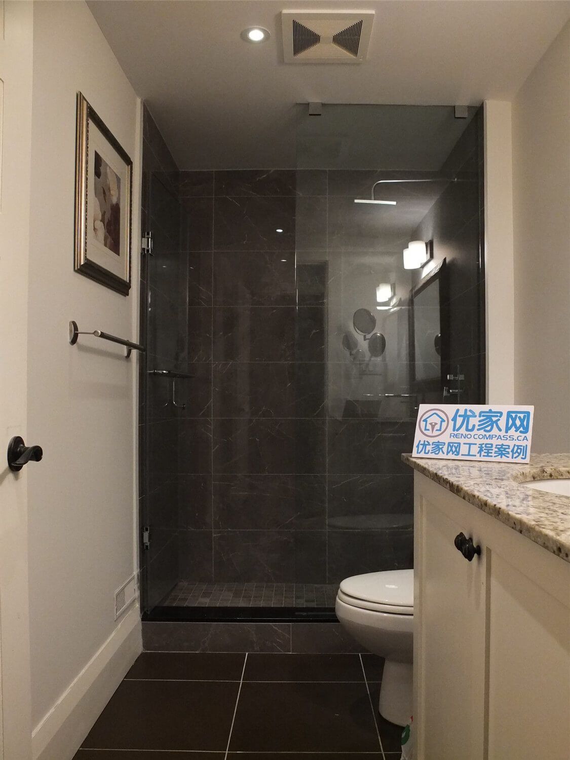 This Oakville basement bathroom renovation features a modern glass shower enclosure with dark tile walls, a granite vanity countertop, and clean white cabinetry. The design combines elegant materials with practical functionality, creating a stylish and comfortable bathroom space. Completed by a professional Toronto Renovation Company, the project highlights precise tile installation, contemporary fixtures, and refined finishing details suitable for modern homes in Oakville and the Greater Toronto Area.