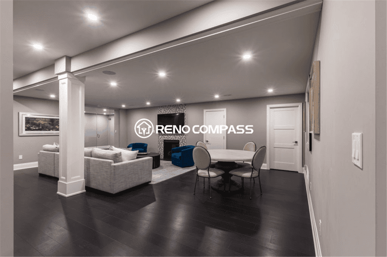 Spacious luxury basement renovation in Toronto featuring an open-concept layout with dark hardwood flooring, recessed ceiling lighting, modern lounge seating, and a stylish entertainment area. This elegant and functional basement living space was professionally designed and completed by a trusted Toronto renovation company, Reno Compass Inc.