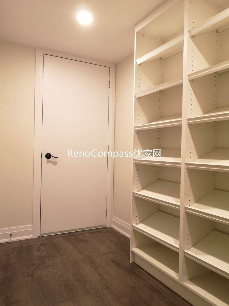Newly finished Richmond Hill basement storage room featuring custom built-in shelving, durable wood flooring, and clean modern lighting. This basement renovation by Reno Compass Inc. improves organization, storage capacity, and everyday functionality for homeowners.