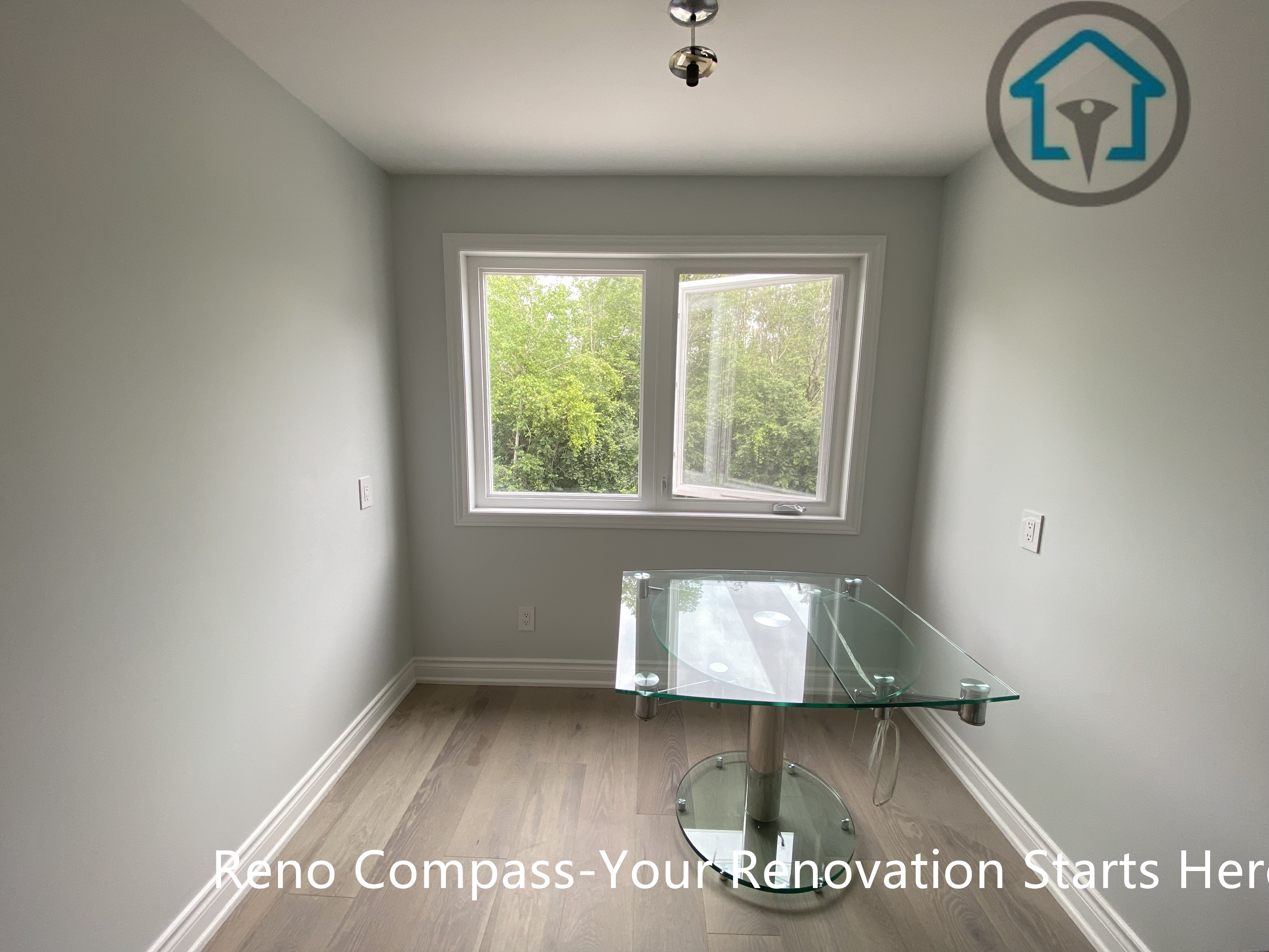 A compact dining area designed with simplicity and balance, featuring large windows that bring in abundant natural light. Neutral wall finishes and warm flooring create a calm, versatile space suitable for daily meals or a home office setup.