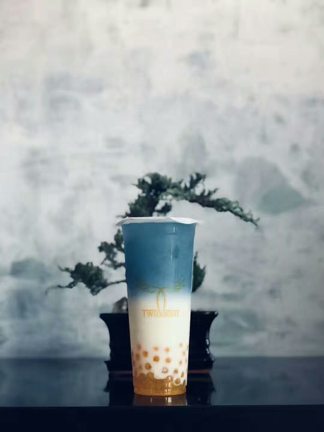 This image showcases a signature bubble tea drink presented inside the renovated Scarborough bubble tea shop. The drink is displayed with the TWILIGHT brand cup design, highlighting the store’s modern aesthetic and clean interior backdrop. The minimalist wall texture and decorative elements create an elegant setting for product presentation. As part of the commercial renovation, the interior environment was designed to enhance the visual appeal of beverages while reinforcing the brand identity of the bubble tea shop.