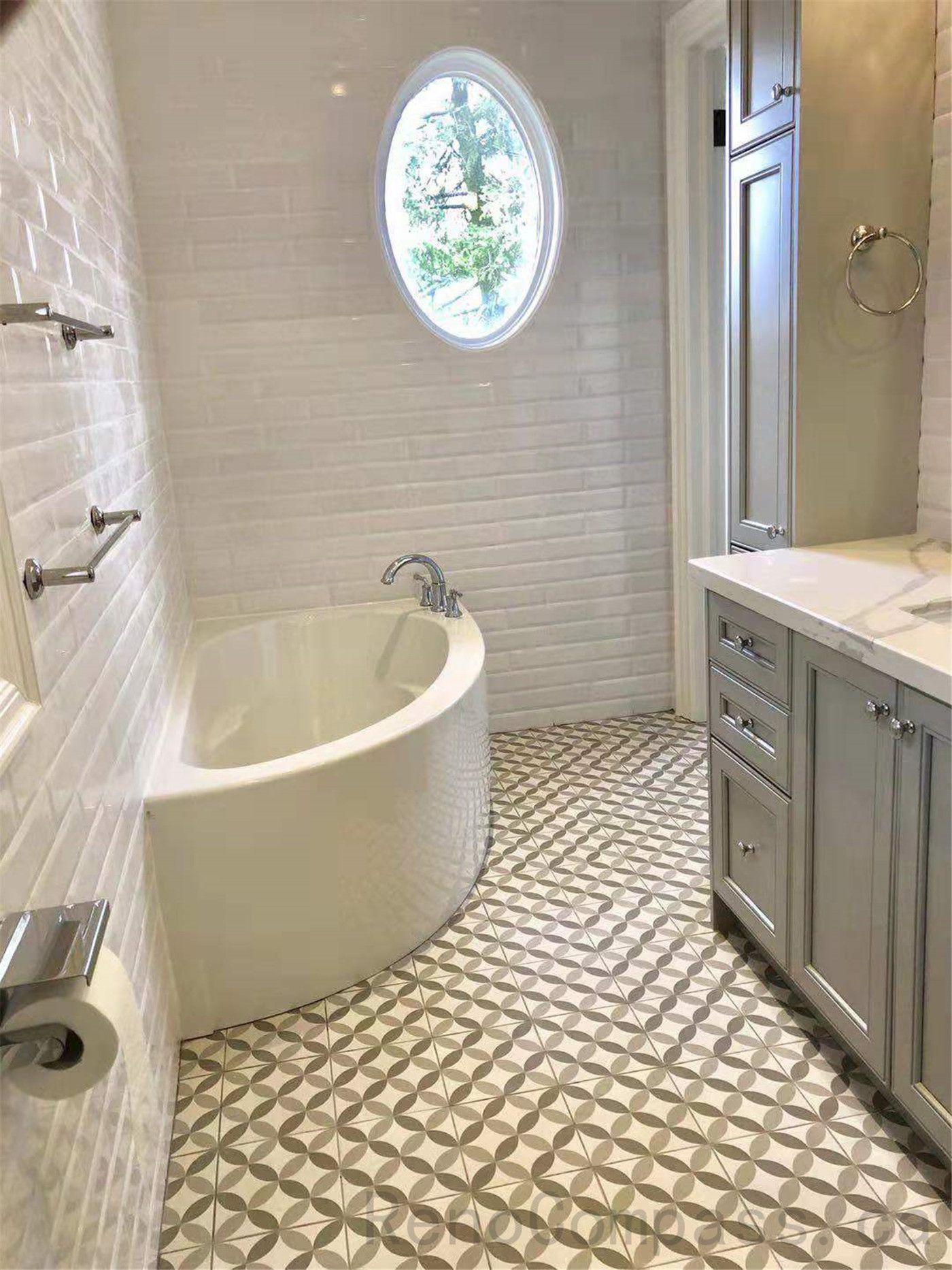 This North York bathroom renovation features a freestanding bathtub, classic white subway wall tiles, and a geometric patterned tile floor that adds visual interest and character. An oval window introduces natural light, creating a bright and relaxing atmosphere. Completed by a professional Toronto renovation company focused on functional design, quality craftsmanship, and timeless bathroom aesthetics.