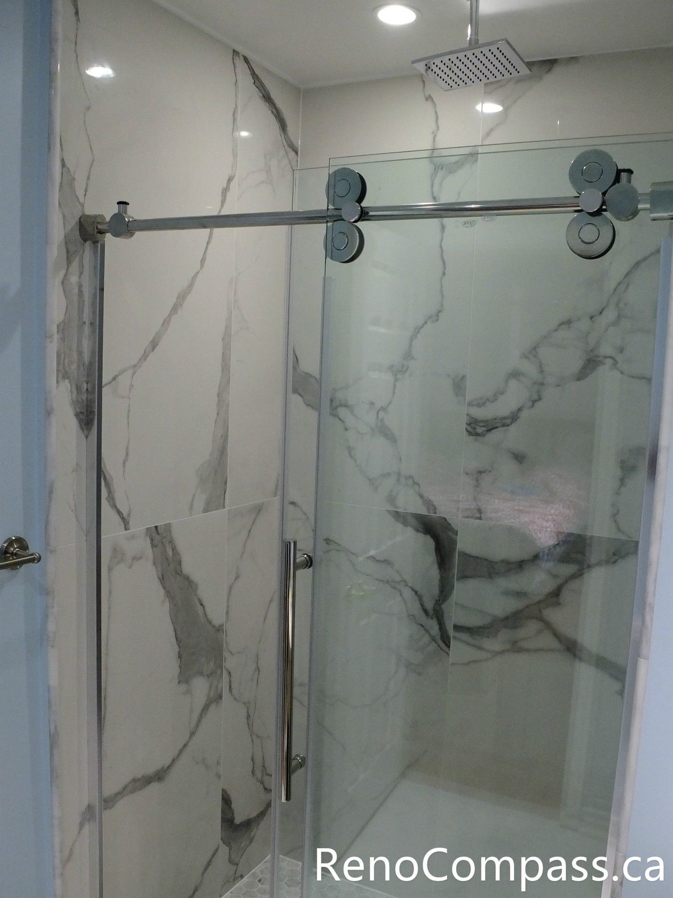 This Richmond Hill bathroom renovation features a sleek frameless glass shower enclosure, marble-look wall tiles, and a clean modern layout designed for comfort and durability. Completed by a professional Toronto renovation company, the space combines elegant finishes with practical functionality, creating a bright and contemporary bathroom upgrade for everyday living.