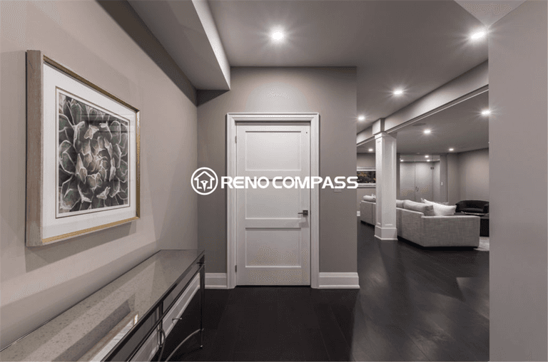 Modern luxury basement renovation in Toronto featuring elegant hallway design, recessed ceiling lighting, dark hardwood flooring, and an open-concept entertainment area. This professionally finished basement space was completed by a trusted Toronto renovation company, Reno Compass Inc., creating a stylish and functional living environment.