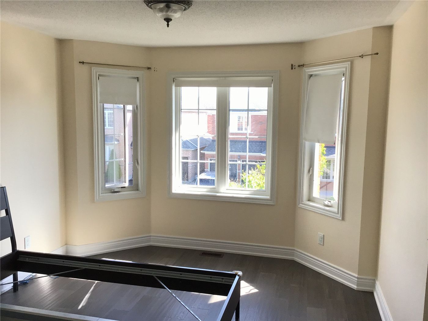 This Woodbridge interior renovation features a bright bedroom with a large bay window, allowing abundant natural light to enhance the space. Finished with wide plank hardwood flooring and clean trim details, the room offers a comfortable and modern living environment.