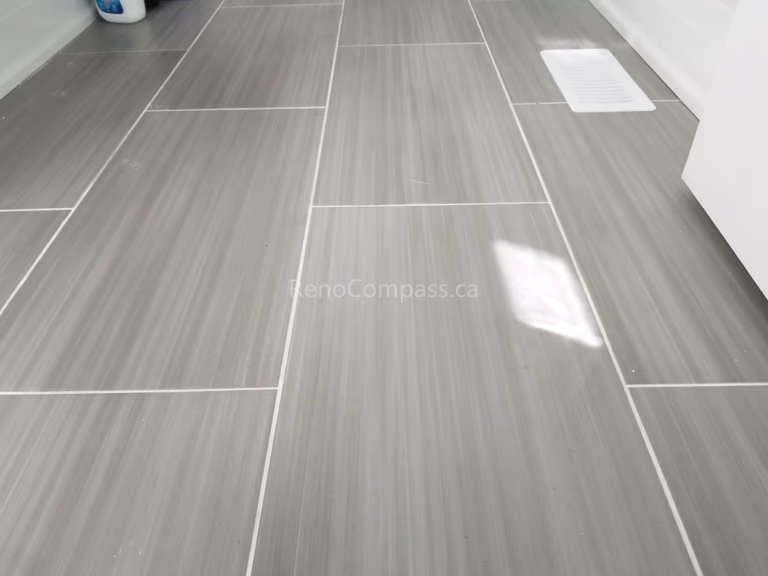 This Toronto interior renovation features high-quality gray porcelain tile flooring with a clean linear pattern and precise grout lines. The durable, low-maintenance tile enhances the space with a modern and elegant finish, ideal for kitchens, bathrooms, or laundry areas. Completed by a professional Toronto renovation contractor, this flooring installation showcases Reno Compass Inc.’s craftsmanship and attention to detail in high-end interior renovations.
