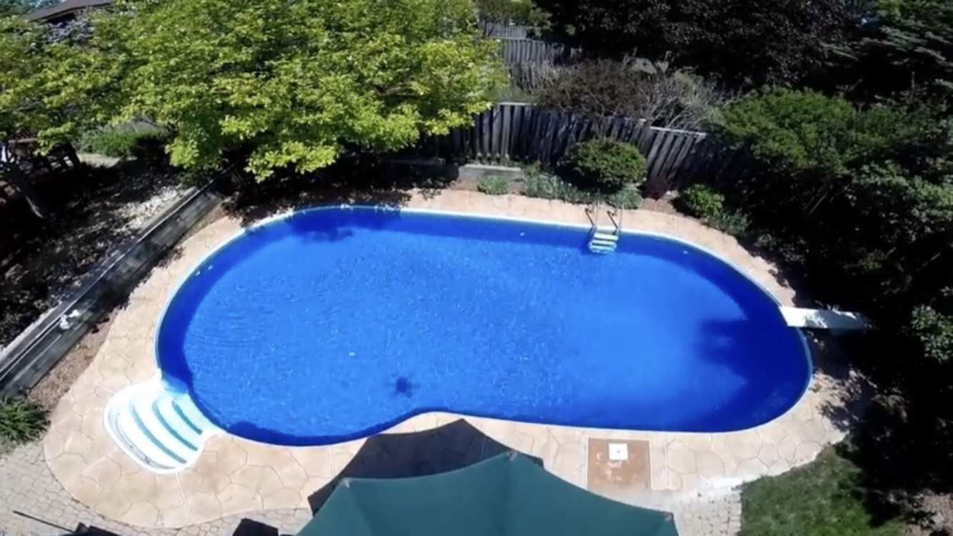 After renovation photo of a fully restored backyard swimming pool in Toronto. The new bright blue liner, clean water, and resurfaced edges highlight the professional pool transformation from old and damaged to modern and inviting. Expert pool renovation by local Toronto specialists.