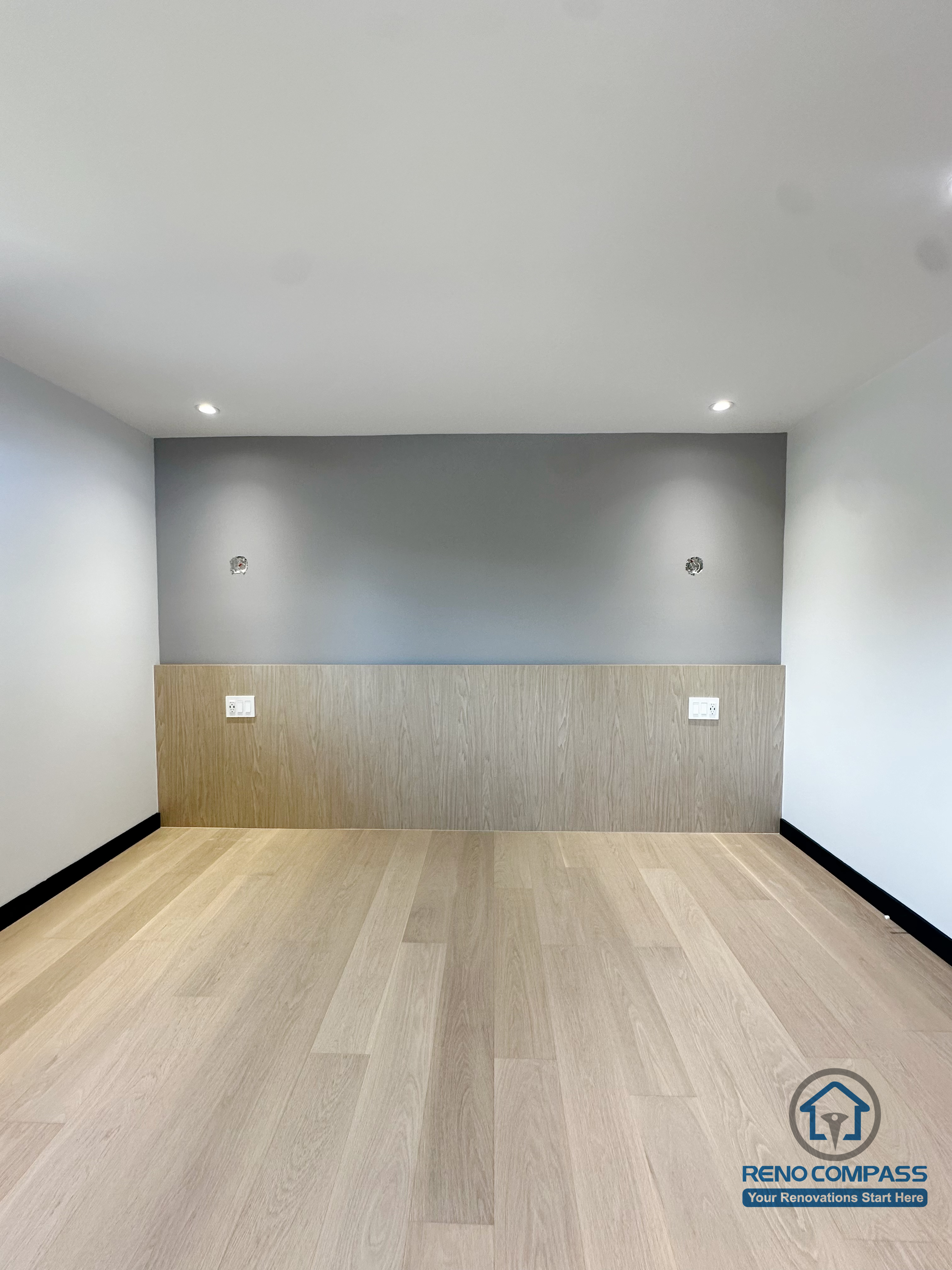 This photo highlights the bedroom feature wall from the Richmond Hill renovation project.
The combination of light wood panels and a smooth grey accent wall creates a clean, modern, and warm atmosphere.
Electrical outlets and wiring have been pre-installed for bedside lighting or smart devices, ensuring both functionality and aesthetics.