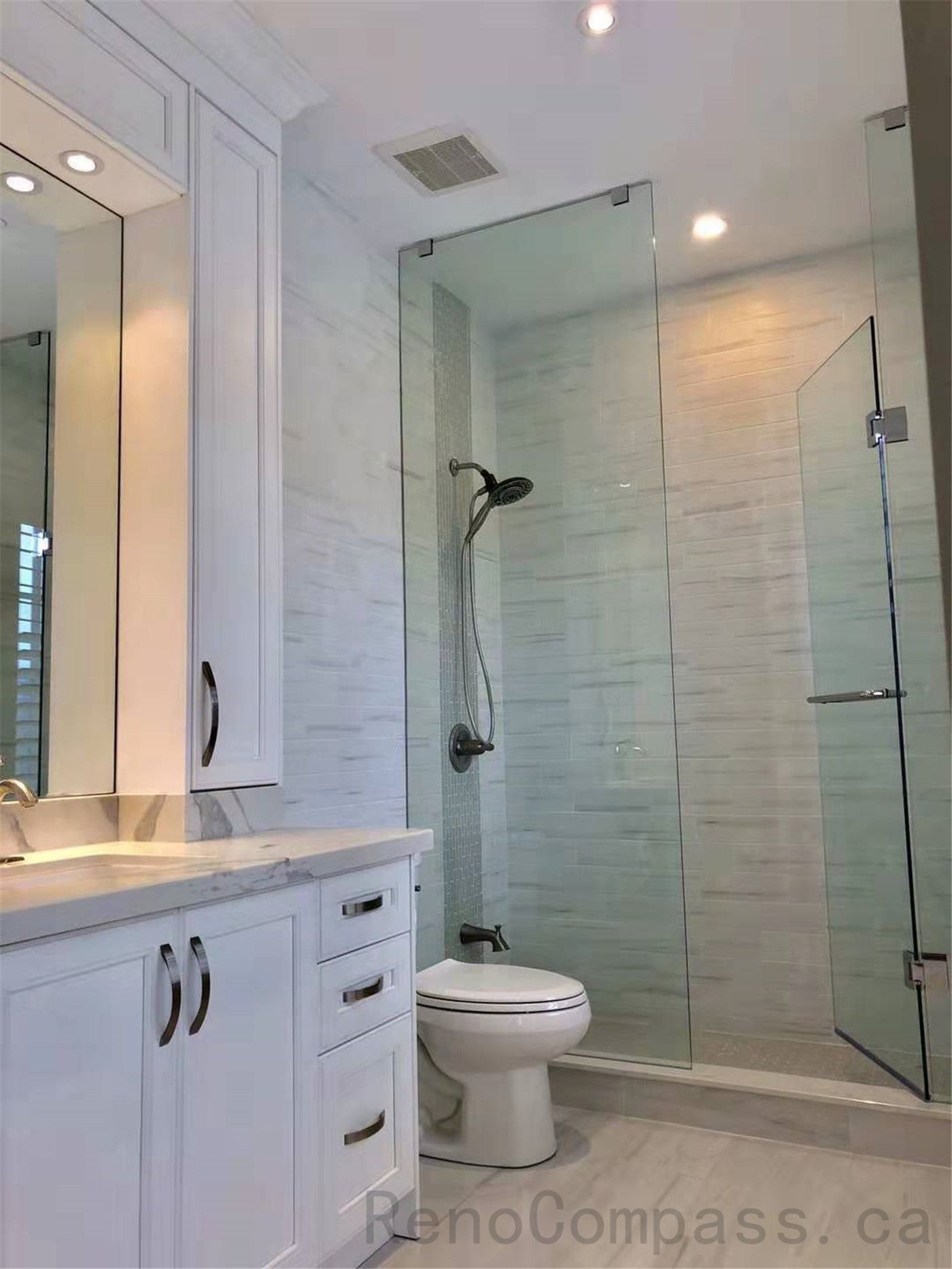 This North York bathroom renovation features a modern glass shower enclosure with marble-look wall tiles, a custom vanity with quartz countertop, and coordinated brushed metal fixtures. The bright layout enhances space, functionality, and everyday comfort while maintaining a clean contemporary style. Completed by a professional Toronto renovation company focused on quality craftsmanship and refined bathroom design.