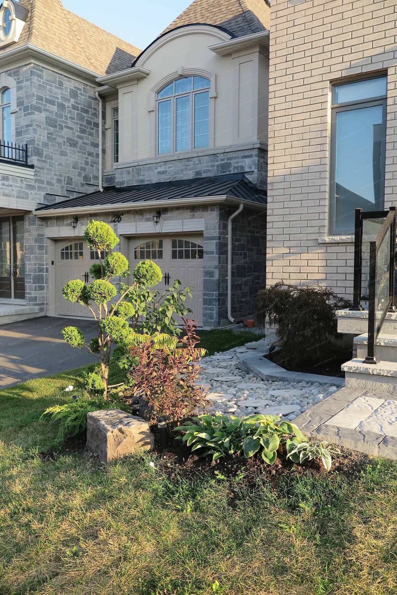 Front yard landscaping design for a detached home in Vaughan featuring decorative garden beds, natural stone accents, ornamental trees, and low-maintenance planting. This landscaping renovation enhances the home's curb appeal while creating a clean and welcoming entrance that complements the driveway and modern exterior architecture.
