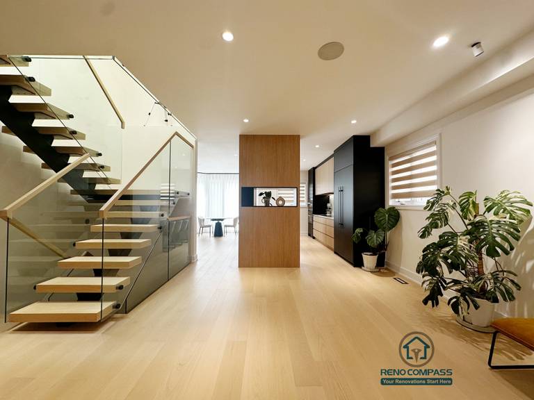 This Markham home renovation features a custom floating steel staircase designed to enhance openness and visual flow. The steel structure is paired with solid wood treads and a tempered glass railing, ensuring safety while maintaining a light, modern appearance. Integrated custom storage along the stair and adjacent areas improves space efficiency, allowing functionality and aesthetics to blend seamlessly within the open-concept layout.