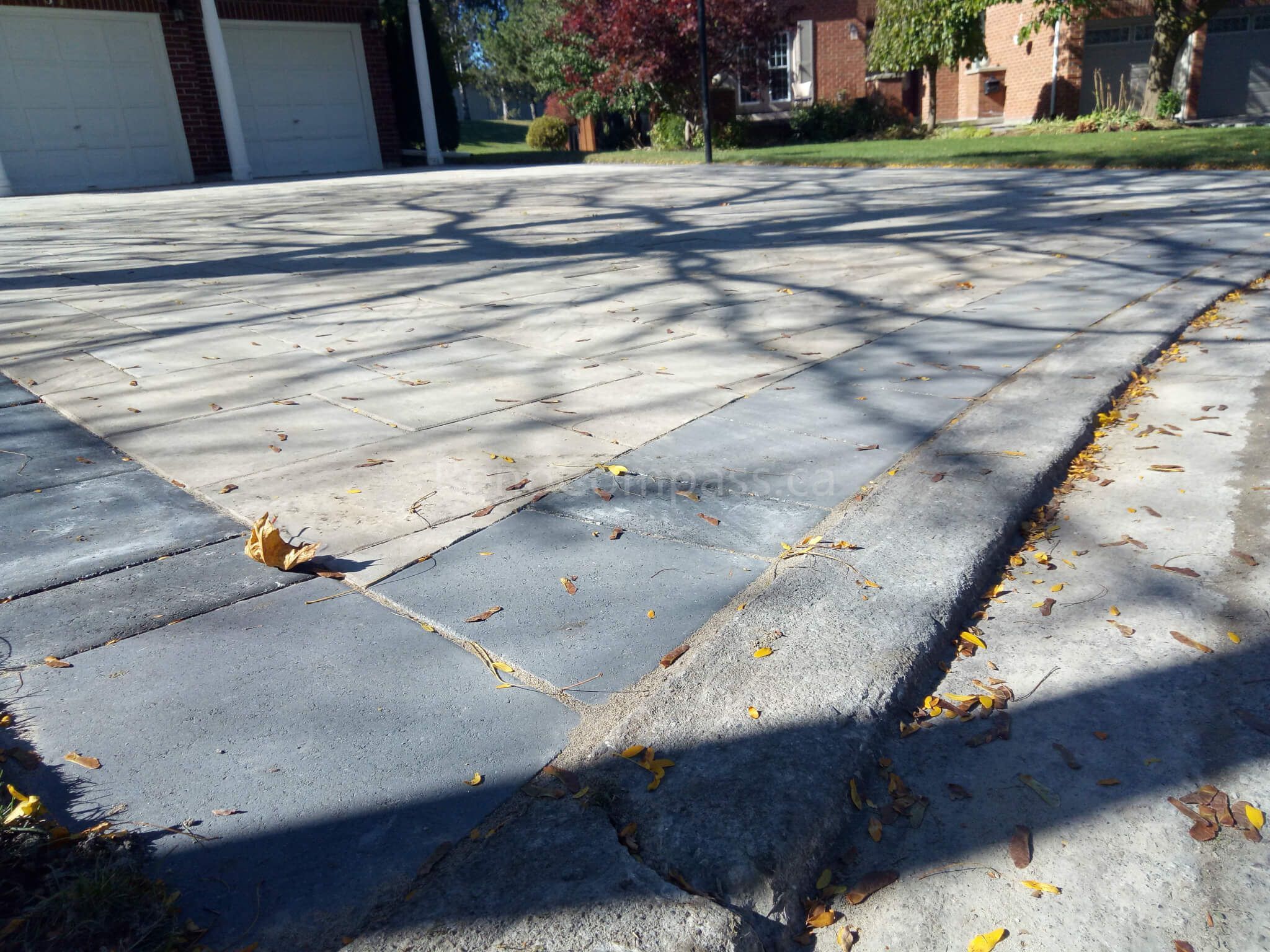 Close-up view of a professionally finished driveway edge in Aurora completed by Reno Compass. The interlocking stone design ensures durability, seamless alignment, and enhanced curb integration. Expertly built for long-lasting beauty and structural strength — ideal for residential landscaping and exterior renovations.