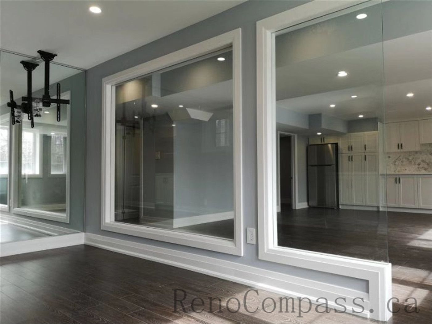 Contemporary basement renovation with a glass partition wall, maximizing natural light and creating an open, seamless flow between spaces. A refined Aurora project designed and built by Reno Compass.
