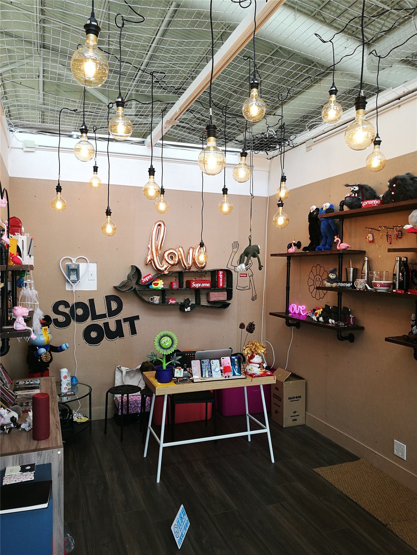 This retail store renovation project at Pacific Mall showcases a modern industrial commercial interior design that blends functionality with visual appeal. The space features an open ceiling concept with warm vintage pendant lighting, creating a welcoming and stylish retail atmosphere. Custom wall shelving and display areas are thoughtfully arranged to maximize product visibility and enhance customer interaction. Dark wood flooring paired with warm lighting adds depth and sophistication to the space, making it ideal for gift shops, collectibles, and lifestyle retail stores. Completed by a professional Toronto commercial renovation team, this project highlights how strategic layout planning and lighting design can elevate both brand presentation and the overall shopping experience.