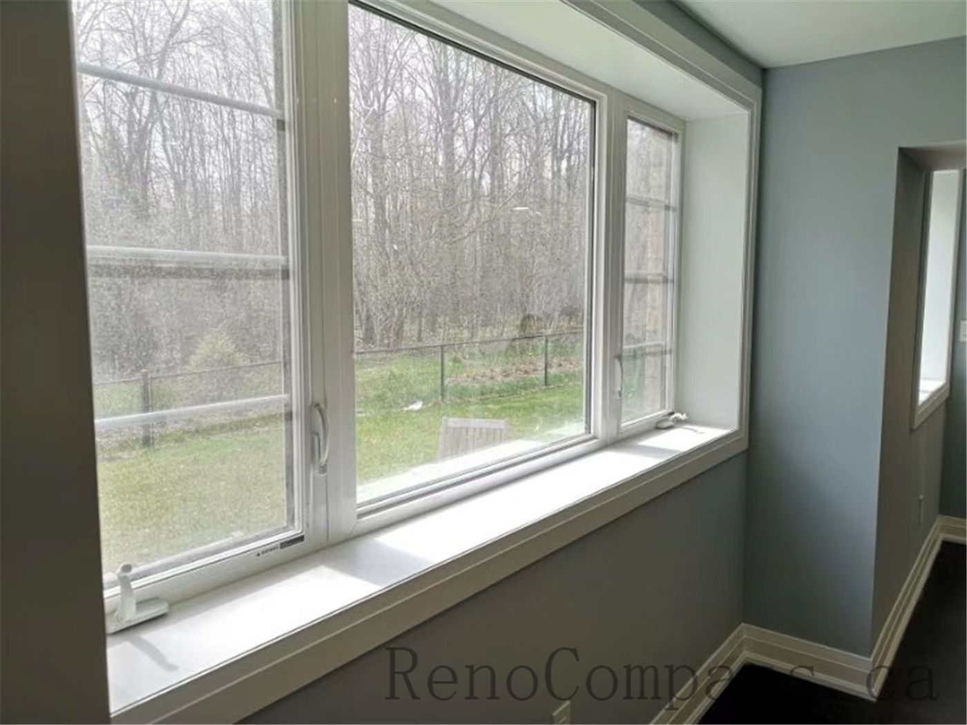 Beautiful natural light fills this renovated Aurora basement, featuring a large window, fresh paint, and dark wood flooring. The open layout adds warmth and comfort to the home’s lower level.
