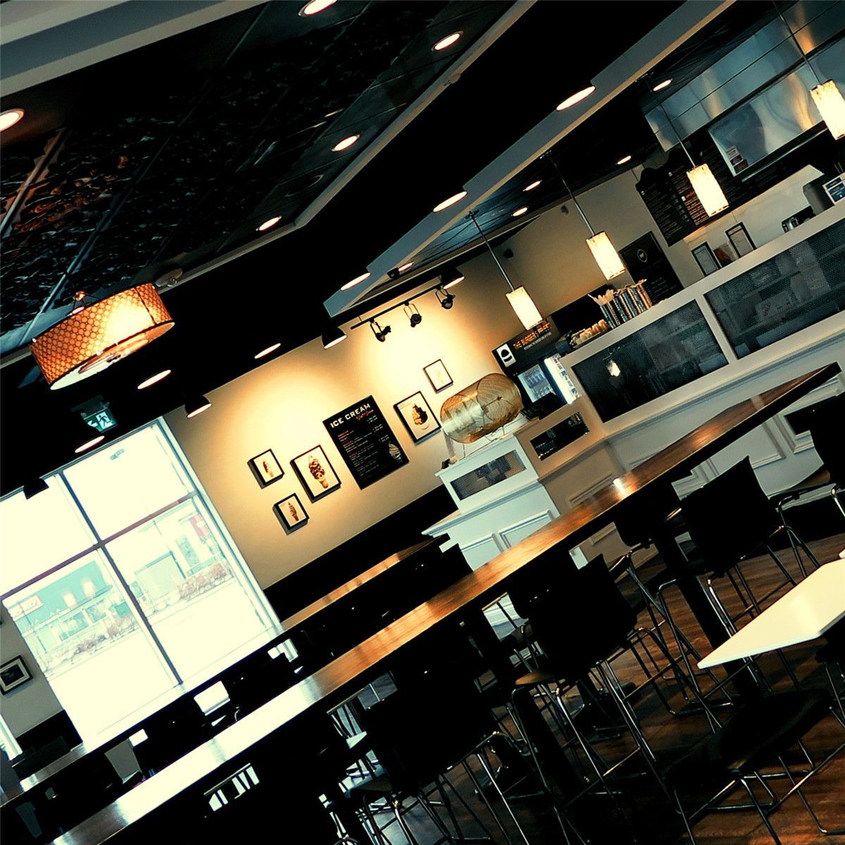 This Toronto burger restaurant renovation highlights the finished dining area layout and interior ambiance completed by Reno Compass Inc. The space features high-top seating arrangements, natural light integration through large front windows, and a balanced combination of pendant and recessed lighting.

The open dining layout maximizes seating capacity while maintaining clear customer circulation pathways. Custom millwork counters, decorative ceiling elements, and durable commercial-grade flooring contribute to a modern and inviting restaurant environment.

As an experienced Toronto Renovation Company, Reno Compass Inc. delivers restaurant interior renovations designed to enhance atmosphere, functionality, and long-term commercial performance.