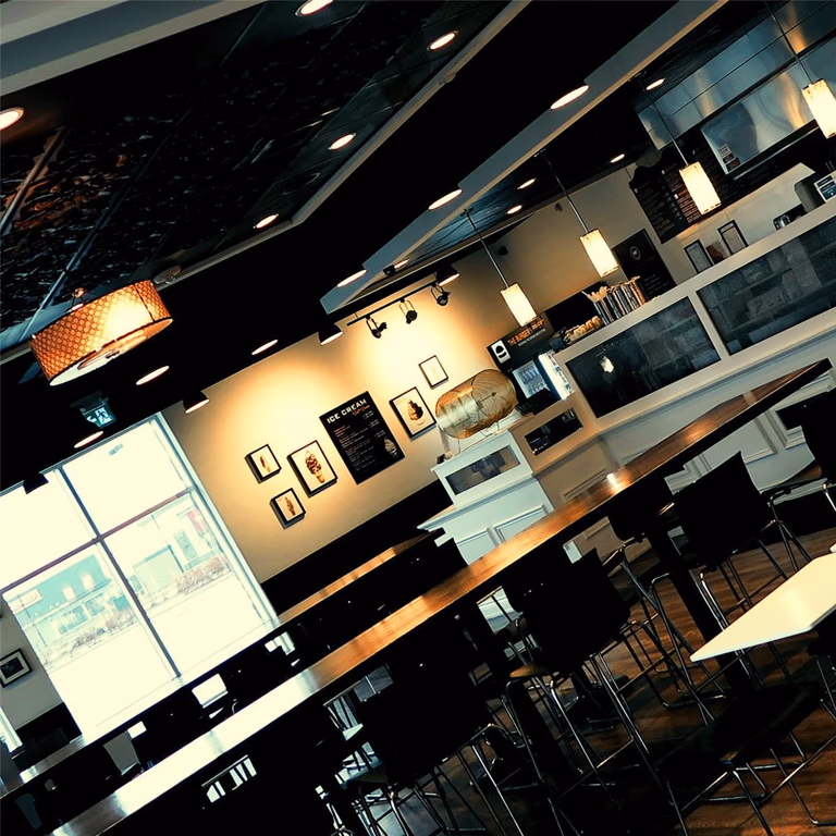This Toronto burger restaurant renovation highlights the finished dining area layout and interior ambiance completed by Reno Compass Inc. The space features high-top seating arrangements, natural light integration through large front windows, and a balanced combination of pendant and recessed lighting.

The open dining layout maximizes seating capacity while maintaining clear customer circulation pathways. Custom millwork counters, decorative ceiling elements, and durable commercial-grade flooring contribute to a modern and inviting restaurant environment.

As an experienced Toronto Renovation Company, Reno Compass Inc. delivers restaurant interior renovations designed to enhance atmosphere, functionality, and long-term commercial performance.