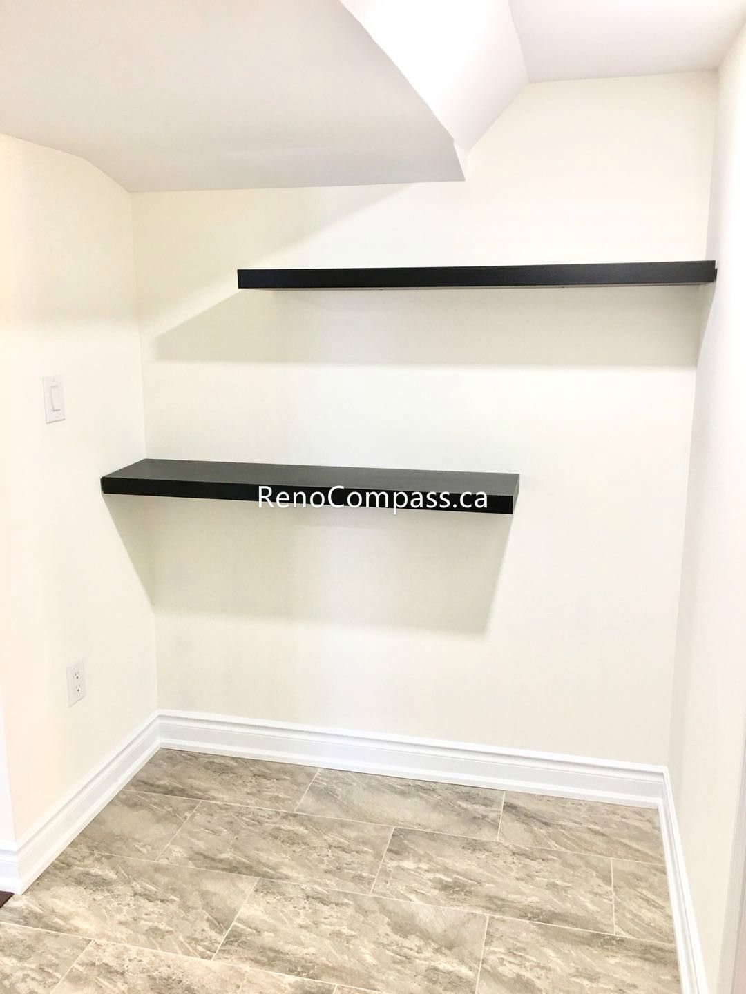 This Toronto basement renovation includes a finished storage or utility area with custom floating shelves, durable tile flooring, and clean modern finishes. The built-in shelving maximizes storage and organization while maintaining a neat and functional basement layout. Completed by a trusted Toronto renovation company, this upgrade improves usability, storage capacity, and overall basement functionality for modern living.