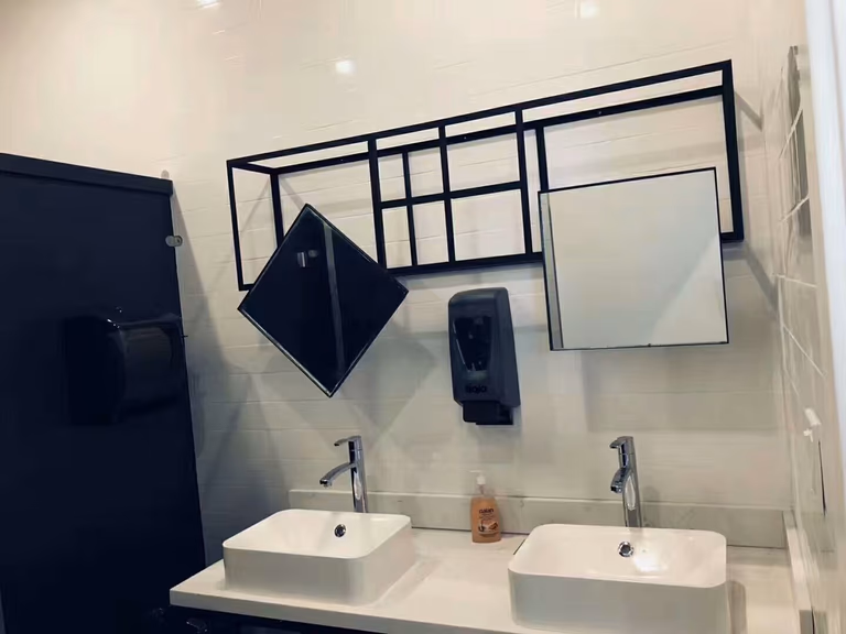 Commercial washroom completed during a North York restaurant renovation project. The space features dual modern vessel sinks, sleek faucets, geometric wall mirrors, and clean tile finishes, creating a contemporary and functional restroom design for customers.