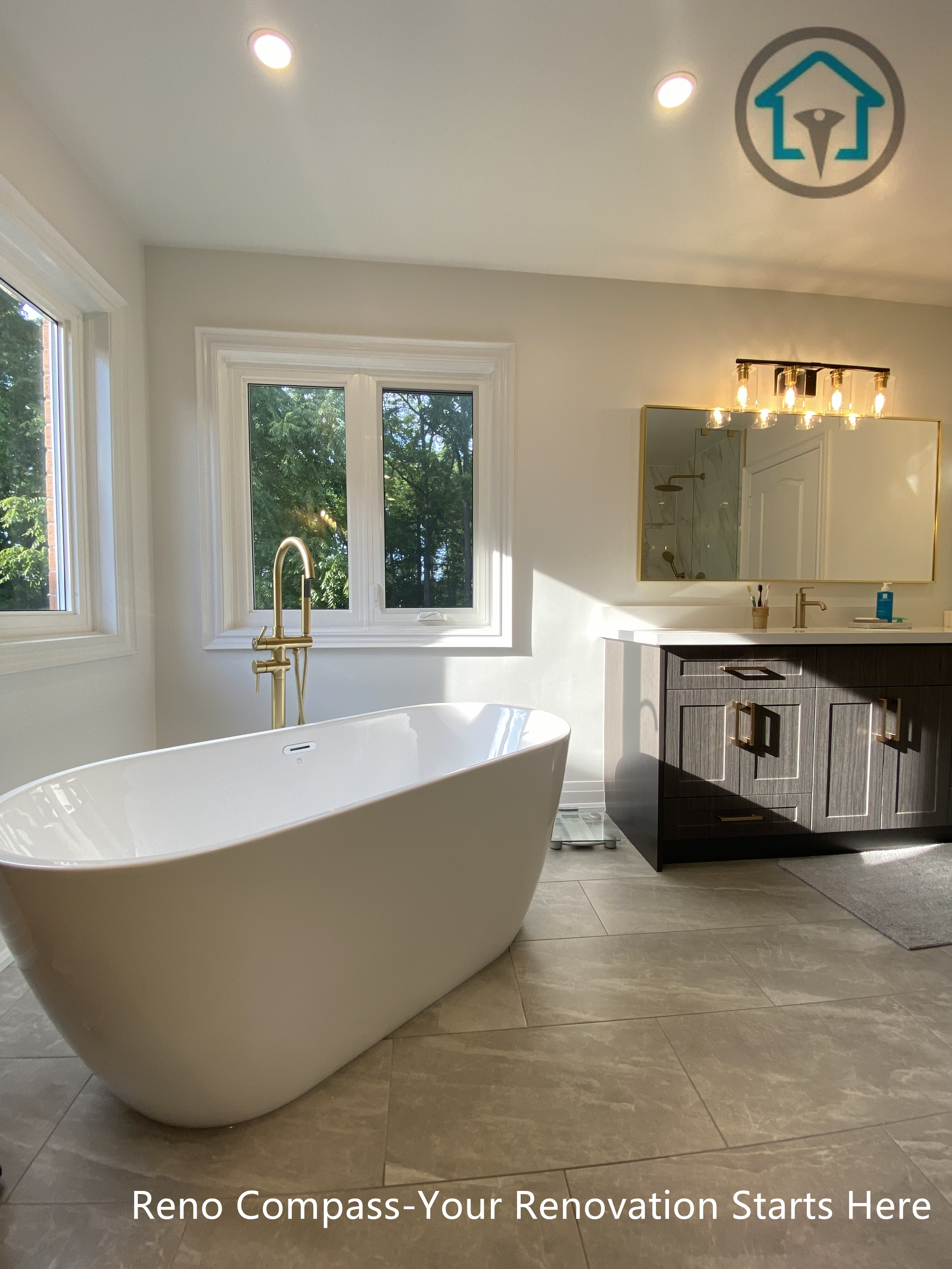 Modern Markham bathroom featuring a freestanding bathtub, warm brass tub filler, large windows, and a clean, spa-inspired layout.