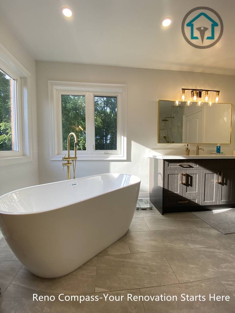 Modern Markham bathroom featuring a freestanding bathtub, warm brass tub filler, large windows, and a clean, spa-inspired layout.
