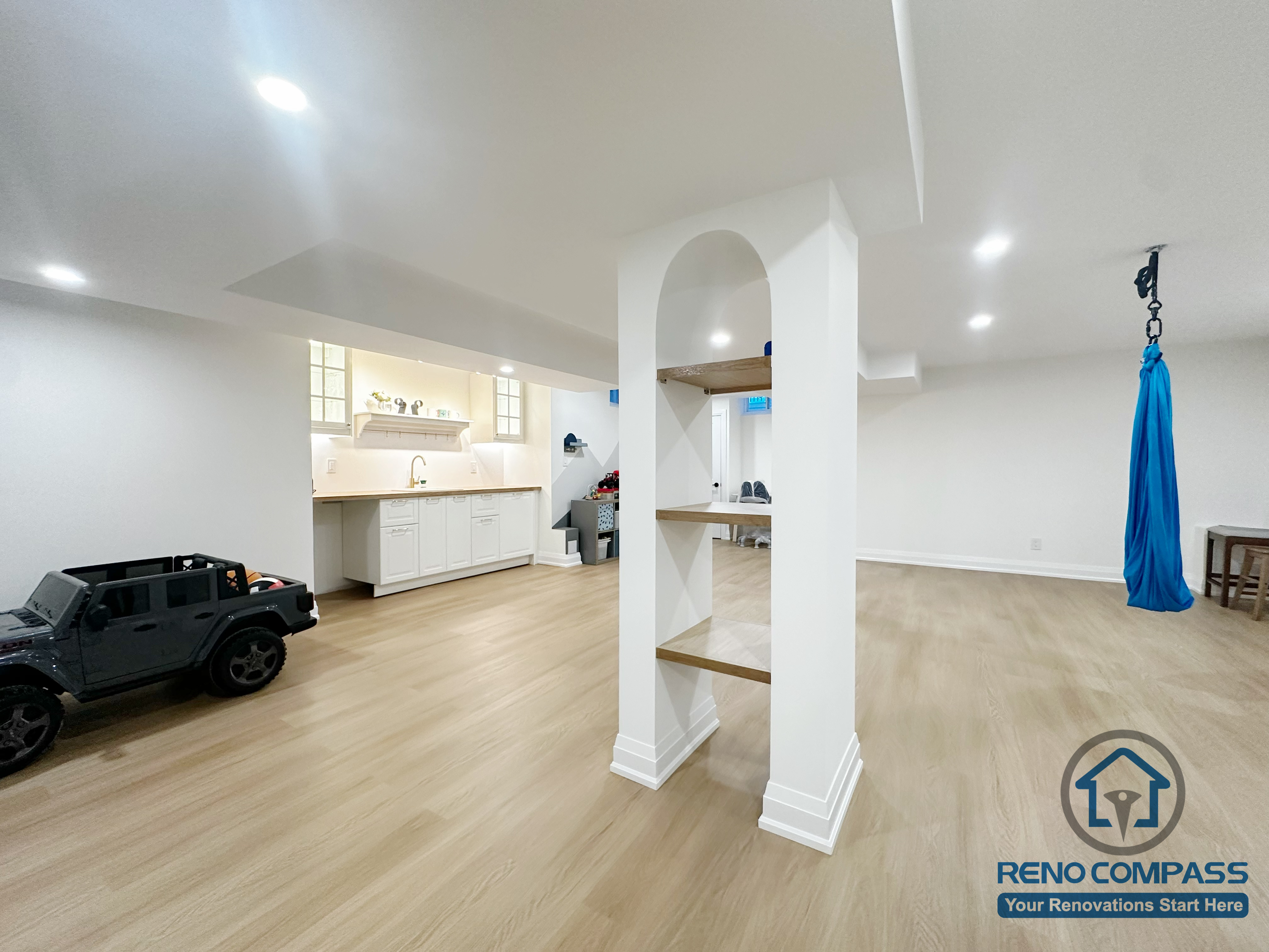 Spacious open-concept basement renovation in Markham featuring custom built-in shelving, recessed lighting, and light wood flooring. The layout supports recreation, play, and future multipurpose use while maintaining a clean, well-structured interior.