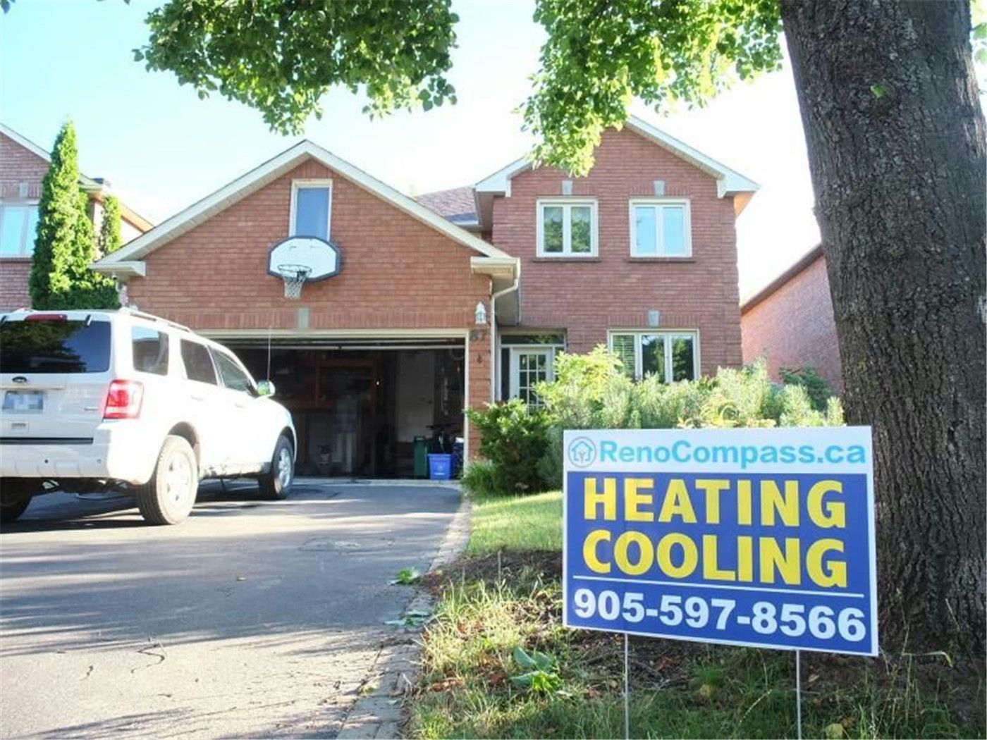 Professional outdoor air conditioner condenser installation by Reno Compass in Toronto. This energy-efficient HVAC unit is securely mounted on a raised stand with proper drainage and ventilation clearance, ensuring optimal cooling performance, durability, and safe operation for residential homes. Installed by licensed technicians for long-term reliability and comfort.