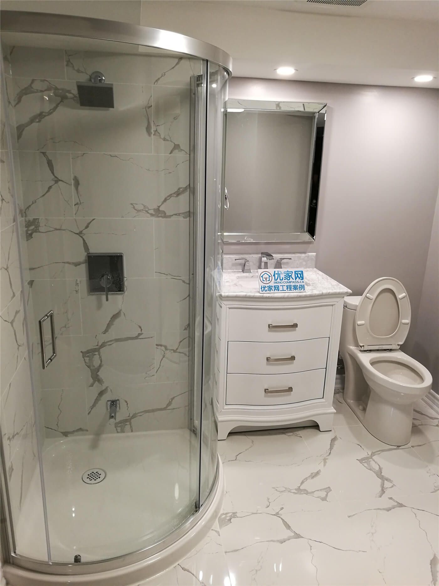 This newly renovated bathroom in Newmarket features elegant marble-pattern tiles that create a clean and luxurious atmosphere. The design emphasizes brightness, durability, and a timeless aesthetic, making the bathroom feel more spacious and refined.