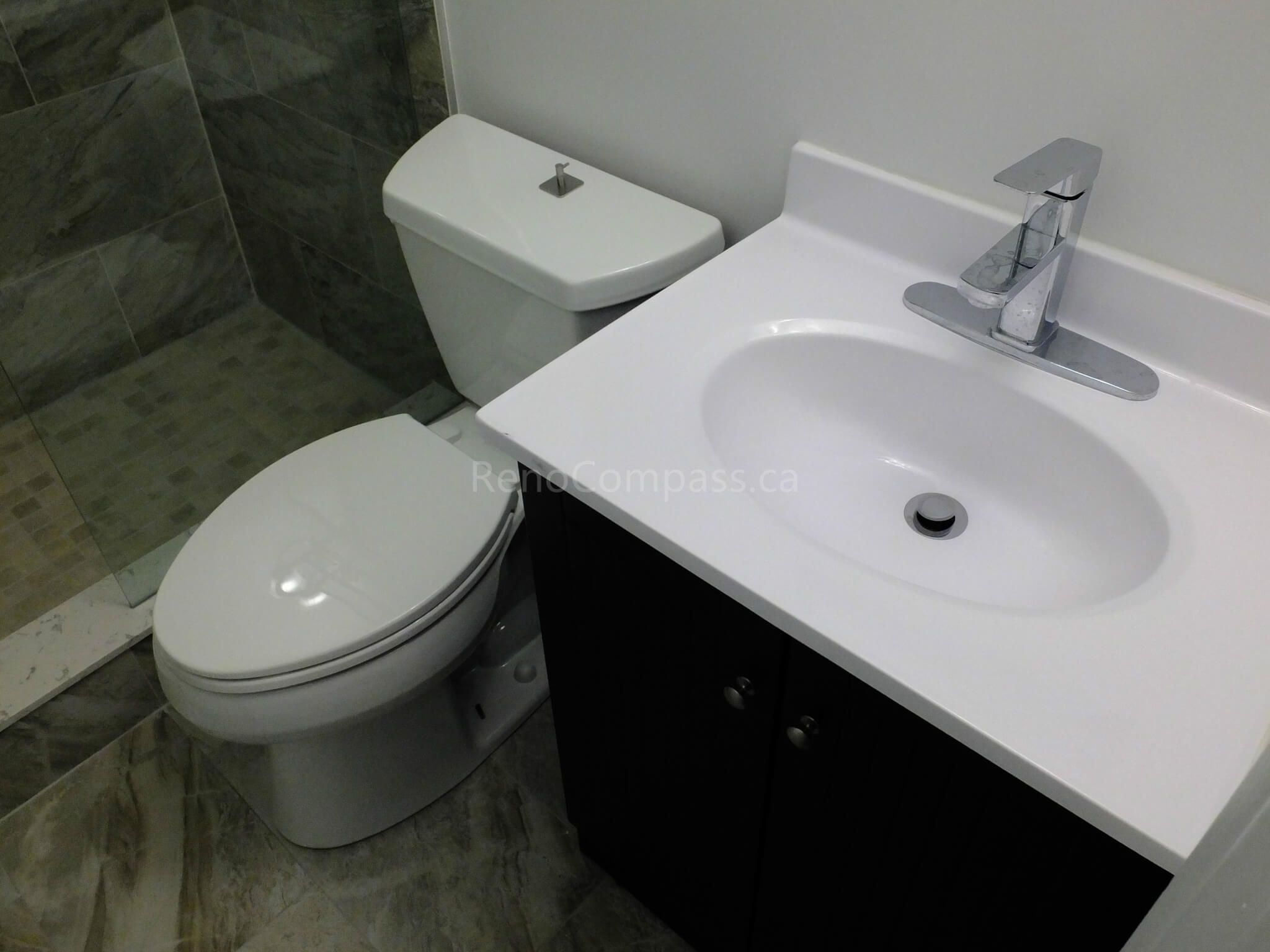 This North York bathroom renovation features a space-efficient vanity and modern toilet installation paired with marble-look floor and wall tiles. Completed by a professional Toronto renovation company, the project focuses on maximizing small bathroom functionality, improving storage, and creating a clean contemporary layout with durable finishes and precise installation.