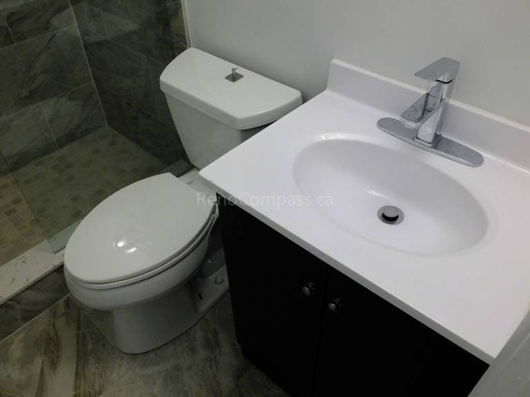 This North York bathroom renovation features a space-efficient vanity and modern toilet installation paired with marble-look floor and wall tiles. Completed by a professional Toronto renovation company, the project focuses on maximizing small bathroom functionality, improving storage, and creating a clean contemporary layout with durable finishes and precise installation.