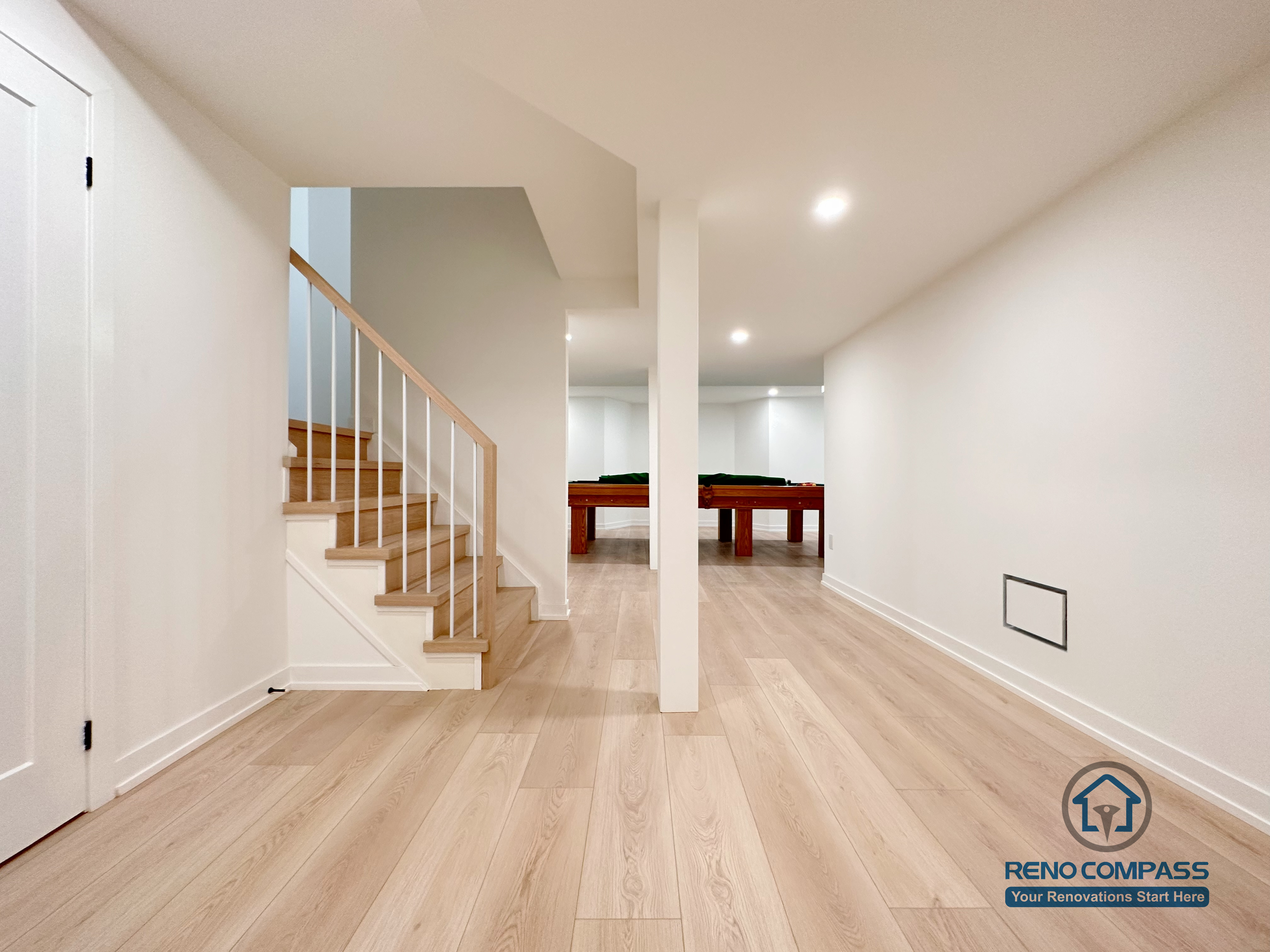 This Markham basement renovation features a clean, open-concept layout with wide-plank flooring, recessed ceiling lights, and a solid wood staircase that creates a seamless connection between levels. Structural columns are carefully integrated to maintain openness while ensuring long-term stability. Designed and completed by a professional Toronto renovation company, this basement space is ideal for a family living area, entertainment zone, or flexible multi-purpose use.