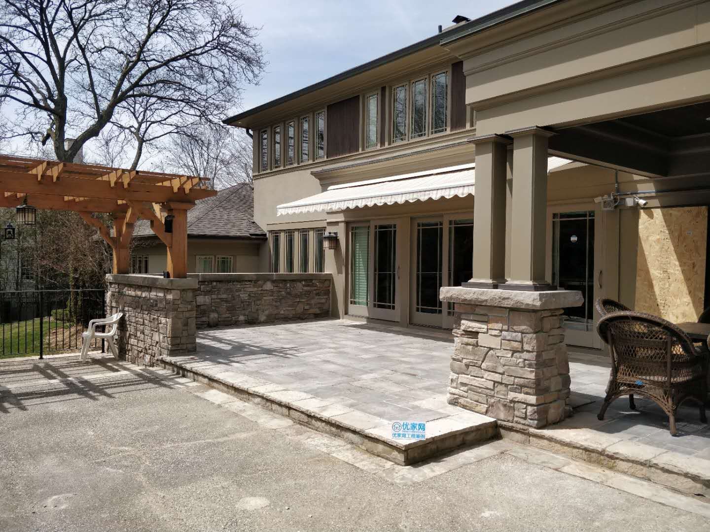 Oakville backyard renovation featuring a spacious interlock stone patio, custom pergola, and stone column detailing. Designed to create a durable, low-maintenance outdoor living and entertaining area.