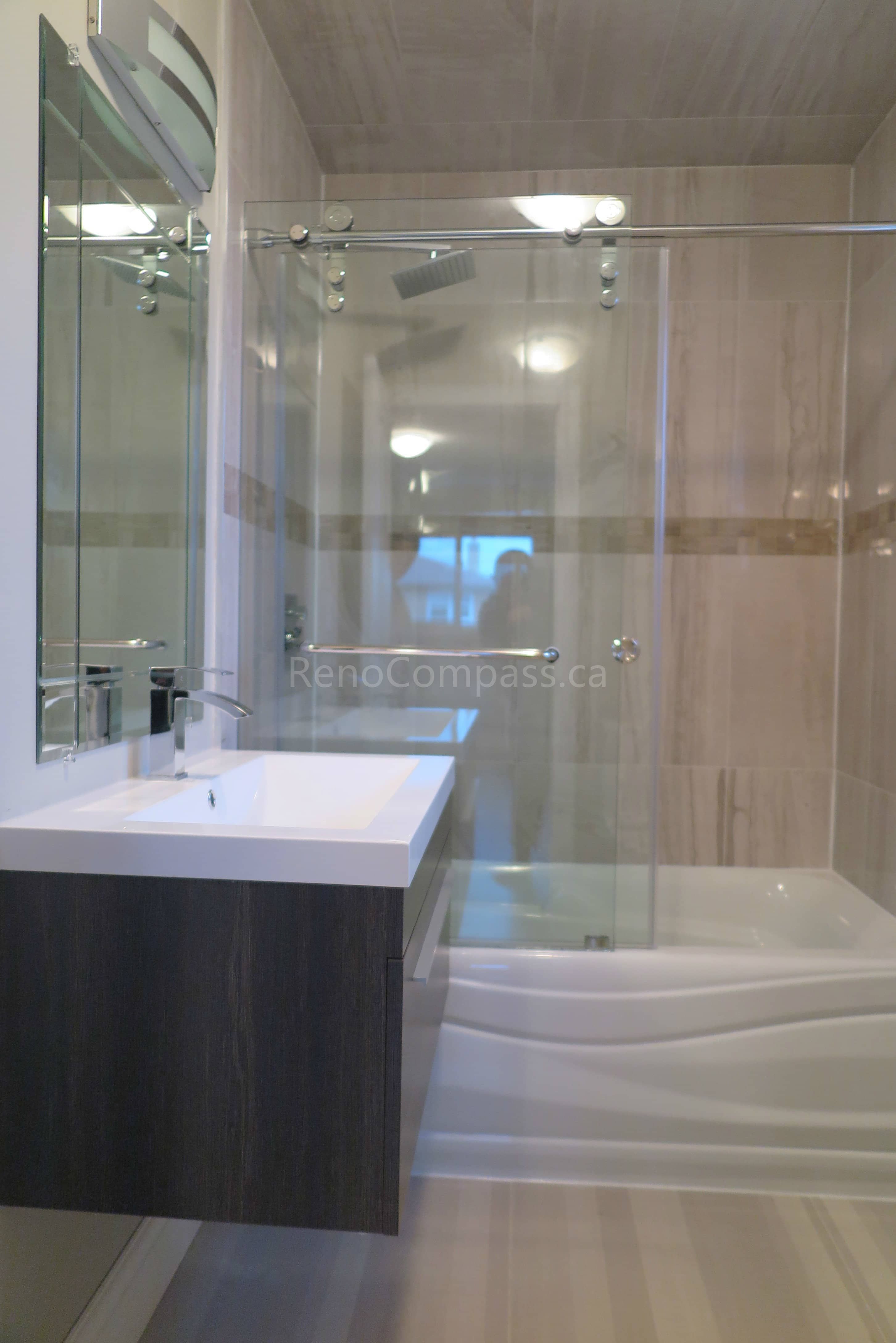 This Markham bathroom renovation features a modern glass-enclosed shower, custom floating vanity with quartz countertop, and elegant large-format wall tiles. The space is designed with clean lines, durable finishes, and contemporary fixtures to create a bright and functional bathroom layout. Completed by Reno Compass, a professional renovation contractor specializing in bathroom renovations and full interior remodeling across Markham and the Greater Toronto Area.