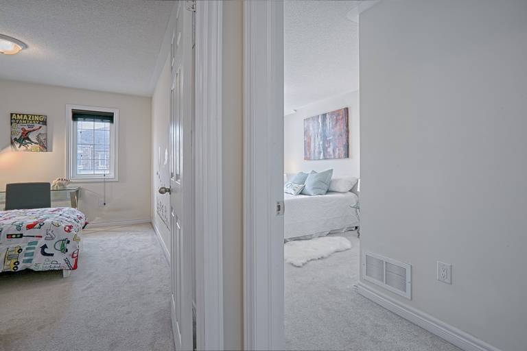 This modern master bedroom renovation showcases a calm and elegant design with soft neutral tones, plush carpeting, and large arched windows that bring in abundant natural light. The clean layout, cozy bedding, and contemporary bedside lighting create a relaxing and comfortable atmosphere ideal for everyday living. Completed by a professional Toronto renovation company, this bedroom upgrade highlights thoughtful space planning and refined interior finishes tailored for modern residential homes.