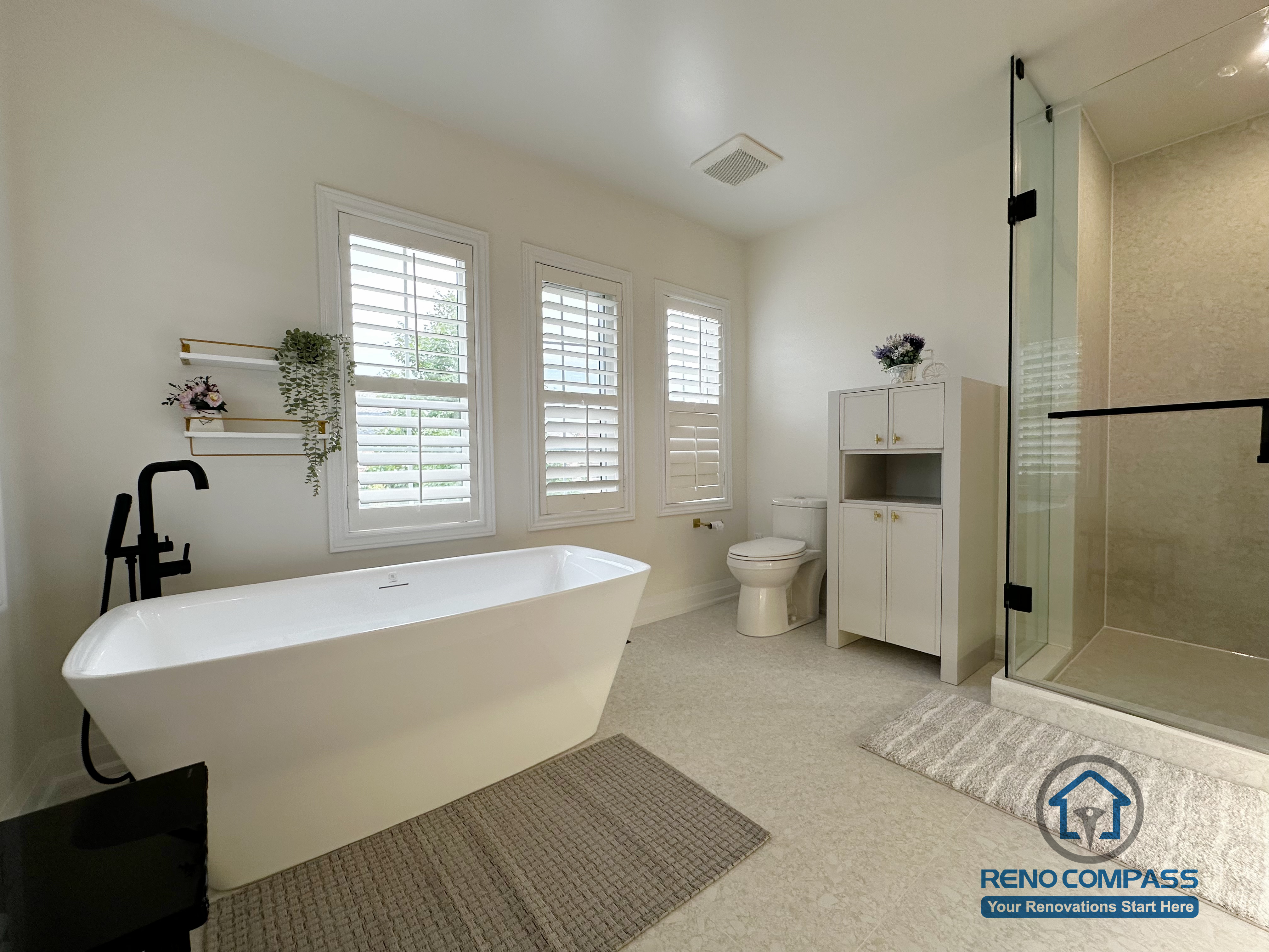 This Markham bathroom renovation showcases a freestanding bathtub set against large windows with plantation shutters. The airy layout, soft neutral finishes, and matte black fixtures create a balanced, spa-like environment that emphasizes natural light, comfort, and everyday functionality.
