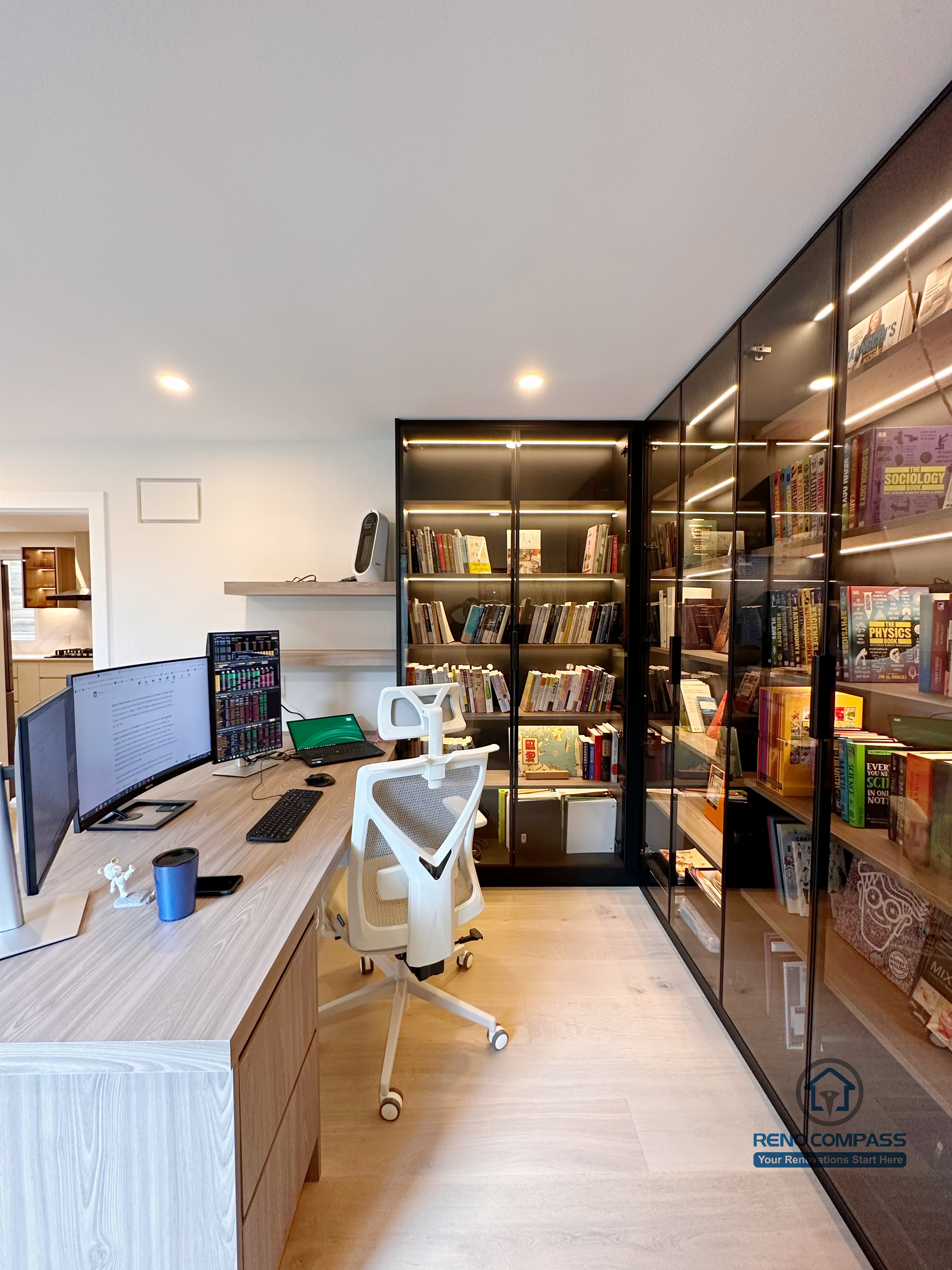 A custom-built home office and library cabinetry project in Toronto featuring floor-to-ceiling glass display bookcases with integrated LED lighting. This tailored storage solution blends workspace functionality with elegant custom cabinetry design, highlighting craftsmanship and space optimization by a professional Toronto renovation company.