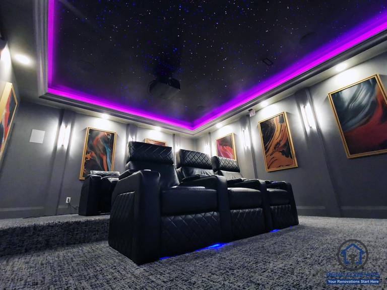 Full view of a custom home theatre renovation in Aurora featuring tiered seating, star ceiling, ambient LED lighting, and a large projection screen for immersive entertainment.