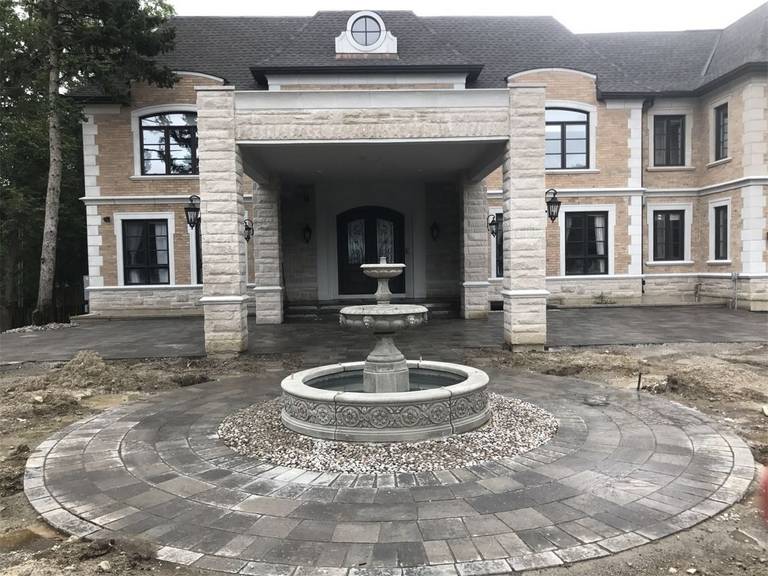 This Markham landscaping renovation showcases a grand circular interlocking stone driveway centered around an elegant decorative fountain, creating a luxurious entrance for the home. The carefully designed stone layout enhances symmetry and curb appeal while providing a durable and visually striking outdoor space. Completed by a professional Toronto Renovation Company, this project highlights refined craftsmanship and high-end landscaping design for a prestigious residential property.
