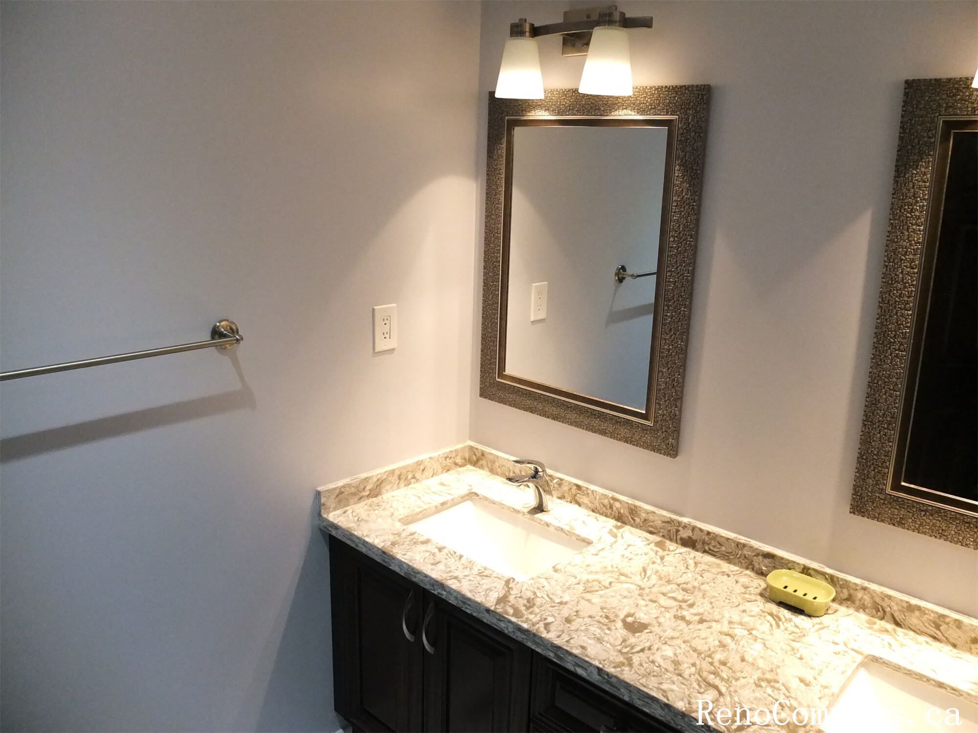 This Richmond Hill interior renovation features a stylish bathroom vanity upgrade with a marble-style quartz countertop, modern undermount sink, and custom cabinetry for improved storage. Elegant wall-mounted lighting and framed mirrors enhance brightness and functionality, creating a clean and contemporary bathroom space. The updated fixtures and finishes provide both durability and timeless appeal for everyday use. Completed by a reliable Toronto renovation company, this bathroom renovation adds comfort, practicality, and long-term value to the home.