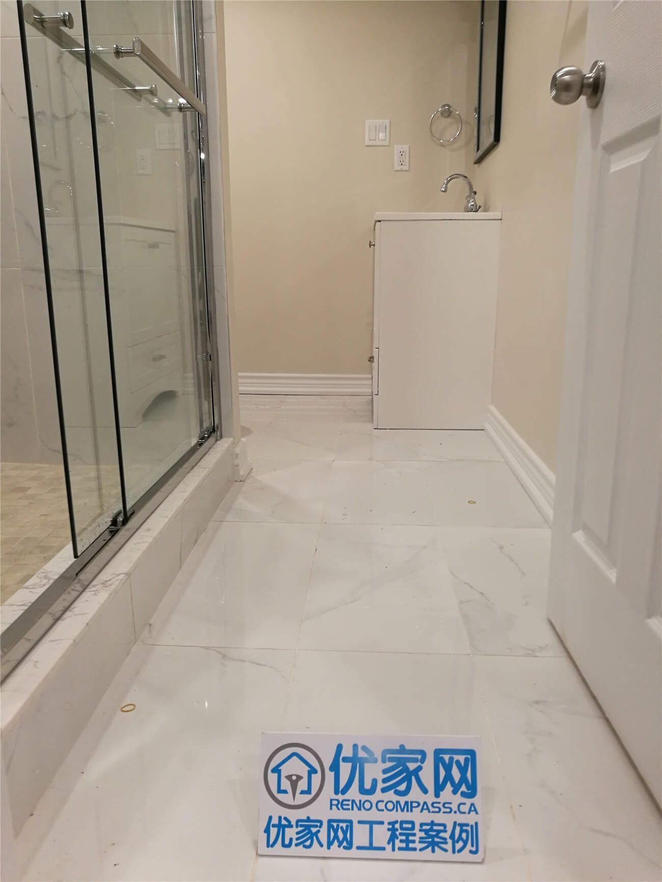 This bathroom interior renovation in Aurora features elegant marble-style floor tiles, a frameless glass shower enclosure, and a compact modern vanity designed for efficient space use. The clean layout and neutral color palette create a bright and functional bathroom environment. As a professional Toronto Renovation Company, Reno Compass focuses on delivering high-quality interior renovation solutions that combine practical design, durable materials, and modern aesthetics for everyday living.