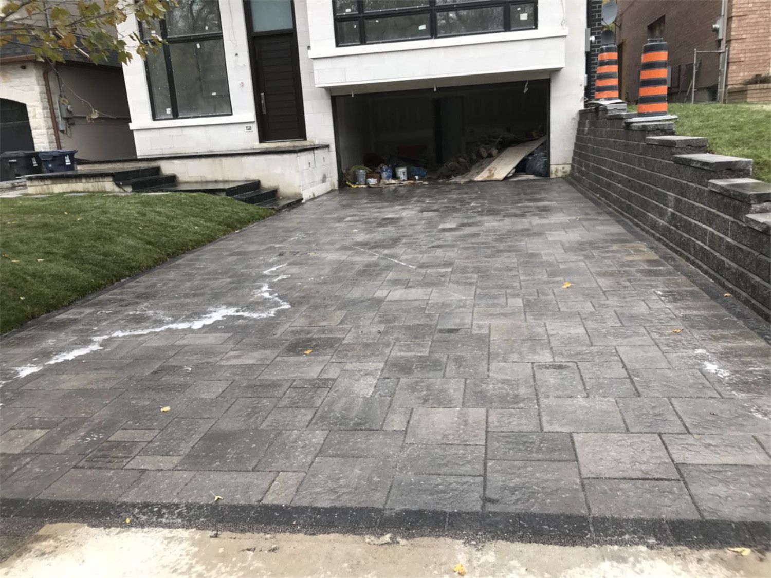 Toronto landscaping renovation featuring custom interlock patio steps and a retaining wall structure designed to create a multi-level backyard outdoor space. The durable paving stones and clean stone edging improve accessibility, drainage, and overall landscape functionality for a Toronto residential property.