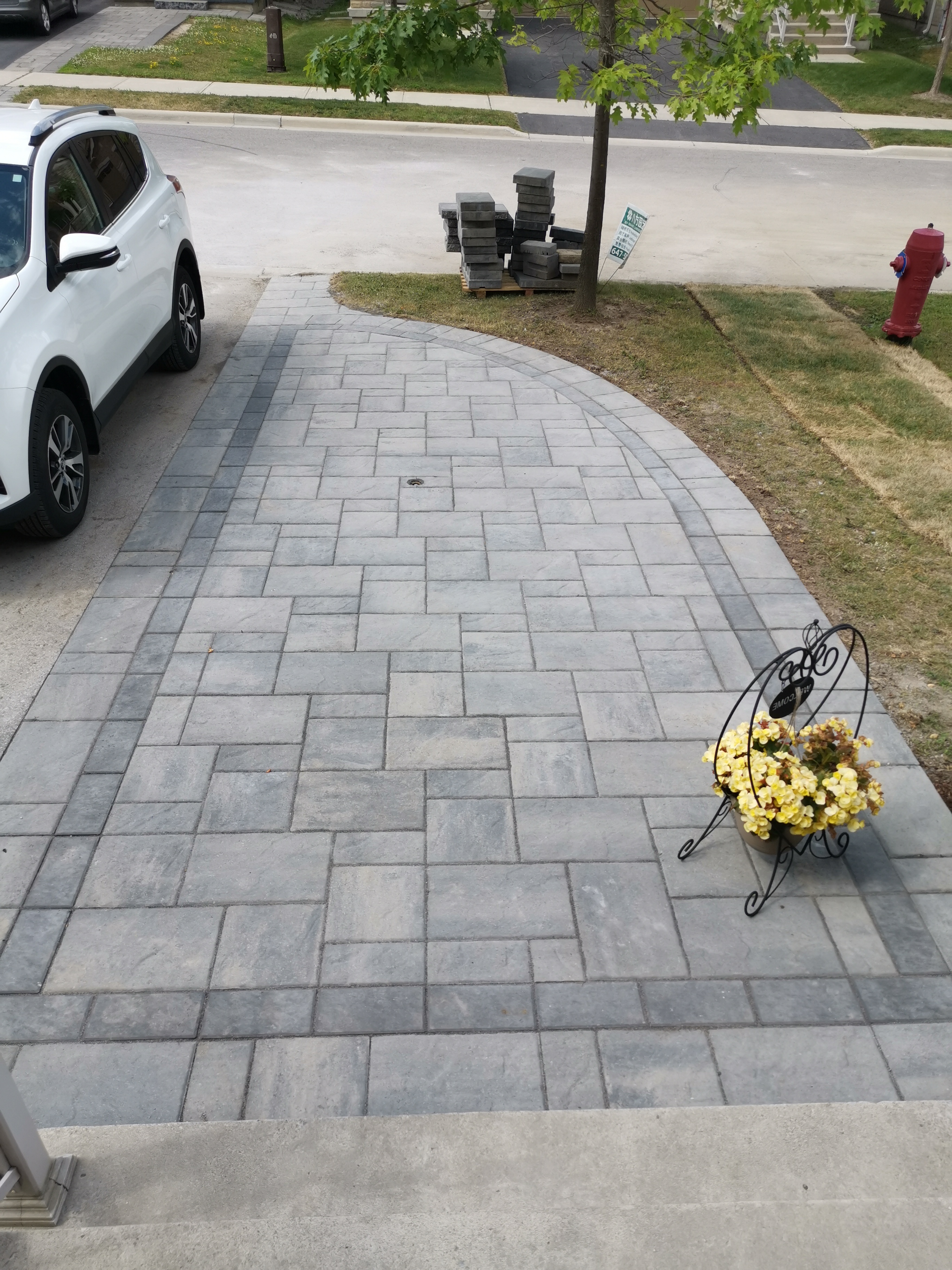 This Aurora front walkway showcases a detailed interlocking paver pattern with clean border accents. The rectangular concrete pavers are carefully arranged to create a balanced, durable walking surface that enhances both safety and visual consistency. The subtle contrast between the main field and border design highlights craftsmanship while supporting proper drainage and long-term performance. This professionally installed interlock walkway detail adds a refined finish to residential front entrances in Aurora.