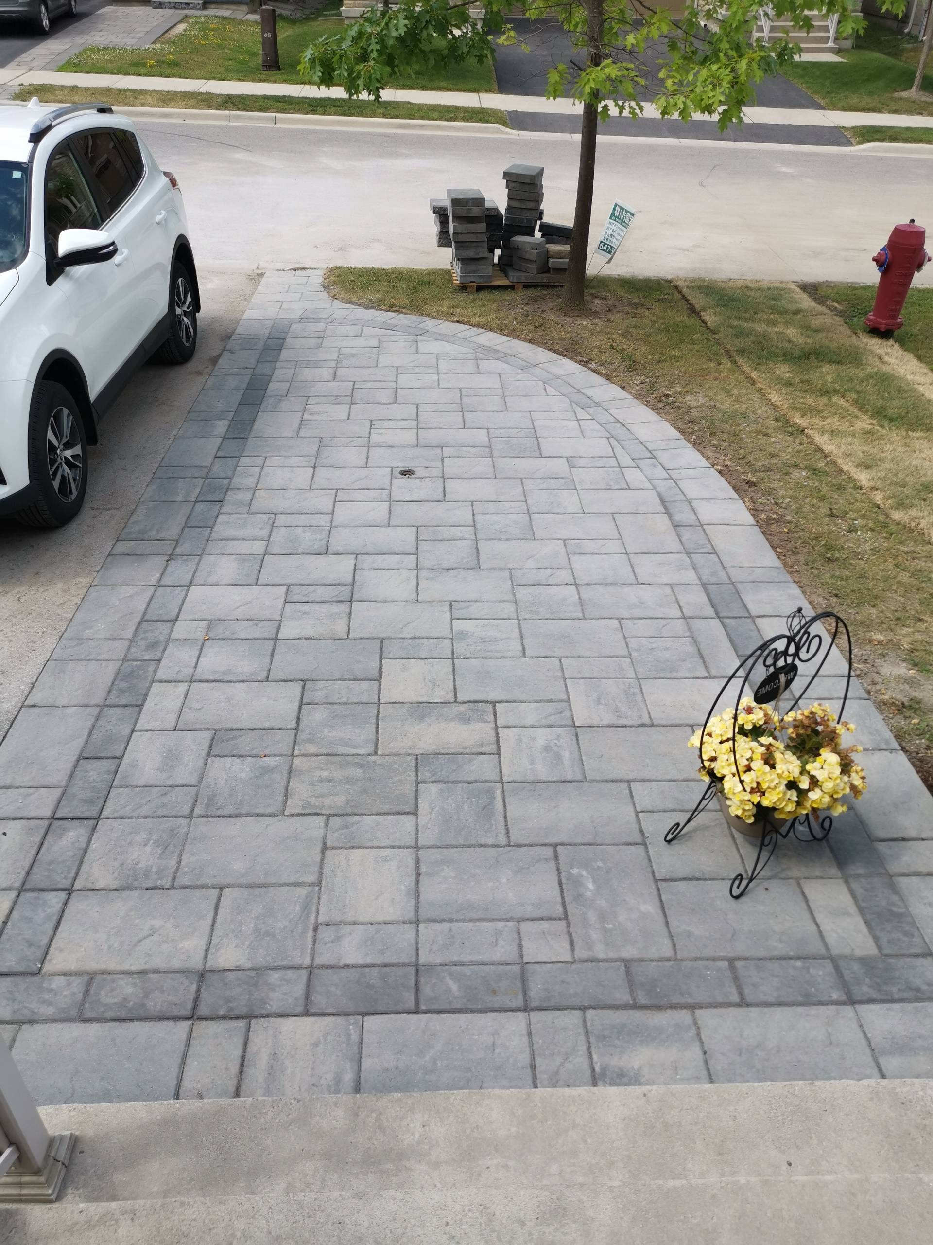 This Aurora front walkway showcases a detailed interlocking paver pattern with clean border accents. The rectangular concrete pavers are carefully arranged to create a balanced, durable walking surface that enhances both safety and visual consistency. The subtle contrast between the main field and border design highlights craftsmanship while supporting proper drainage and long-term performance. This professionally installed interlock walkway detail adds a refined finish to residential front entrances in Aurora.