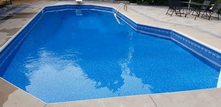 After renovation photo of a fully restored backyard swimming pool in Toronto. The new bright blue liner, clean water, and resurfaced edges highlight the professional pool transformation from old and damaged to modern and inviting. Expert pool renovation by local Toronto specialists.