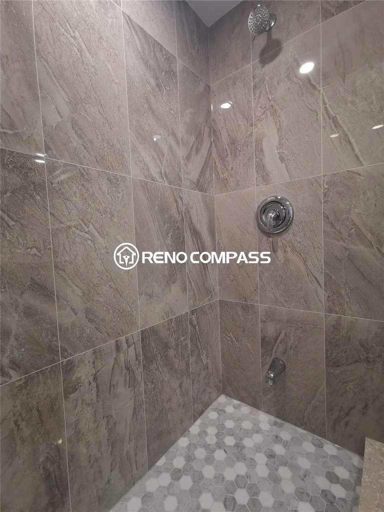 This Markham basement renovation features a modern walk-in shower with full-height marble-look porcelain tile walls and detailed mosaic shower flooring for enhanced slip resistance and visual appeal. Chrome fixtures and clean grout lines create a sleek, contemporary bathroom design while ensuring durability and easy maintenance. The shower upgrade improves both functionality and comfort, transforming the basement into a fully usable living space. Completed by a trusted Toronto renovation company, this project highlights professional tile installation, waterproofing quality, and refined finishing suited for long-lasting residential use in the Greater Toronto Area.